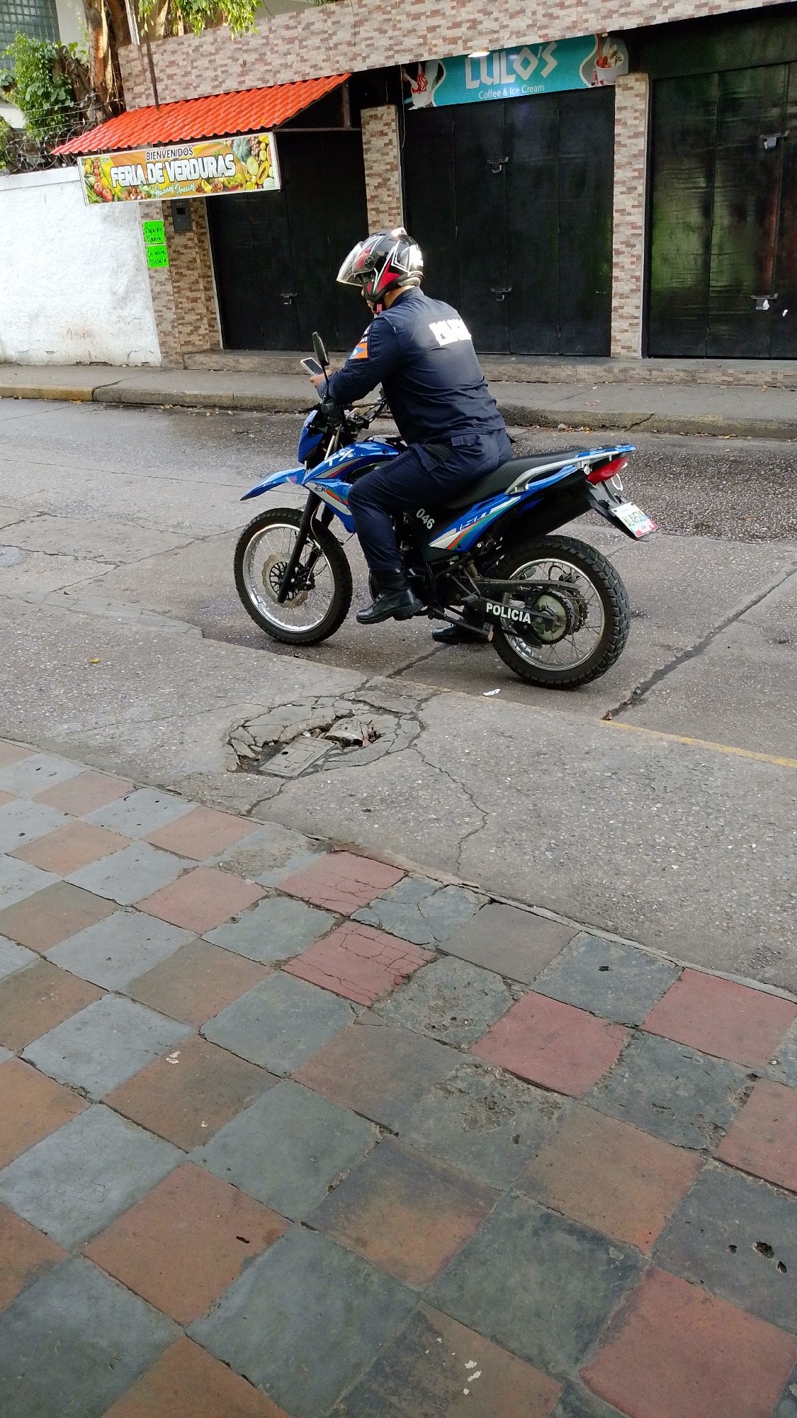 Police officer patrols Tinaquillo streets on blue motorcycle