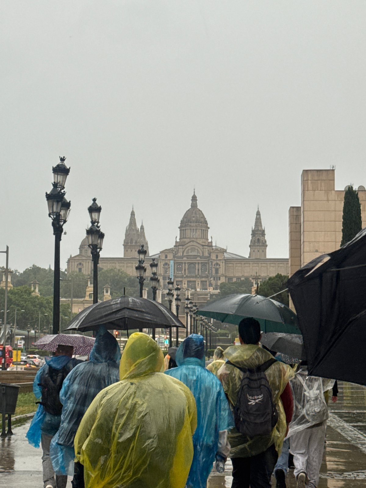 Rain soaks Barcelona's Plaça d'Espanya as visitors brave weather