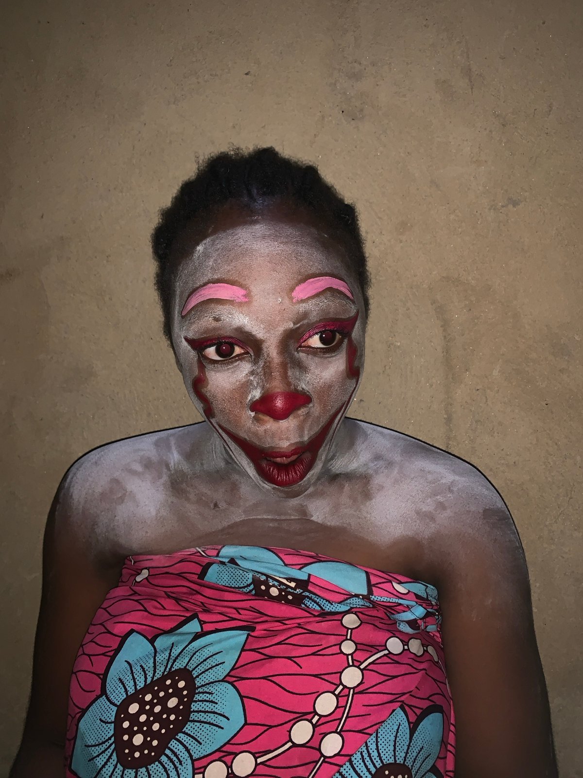 Clown performer balances objects in Nigerian village