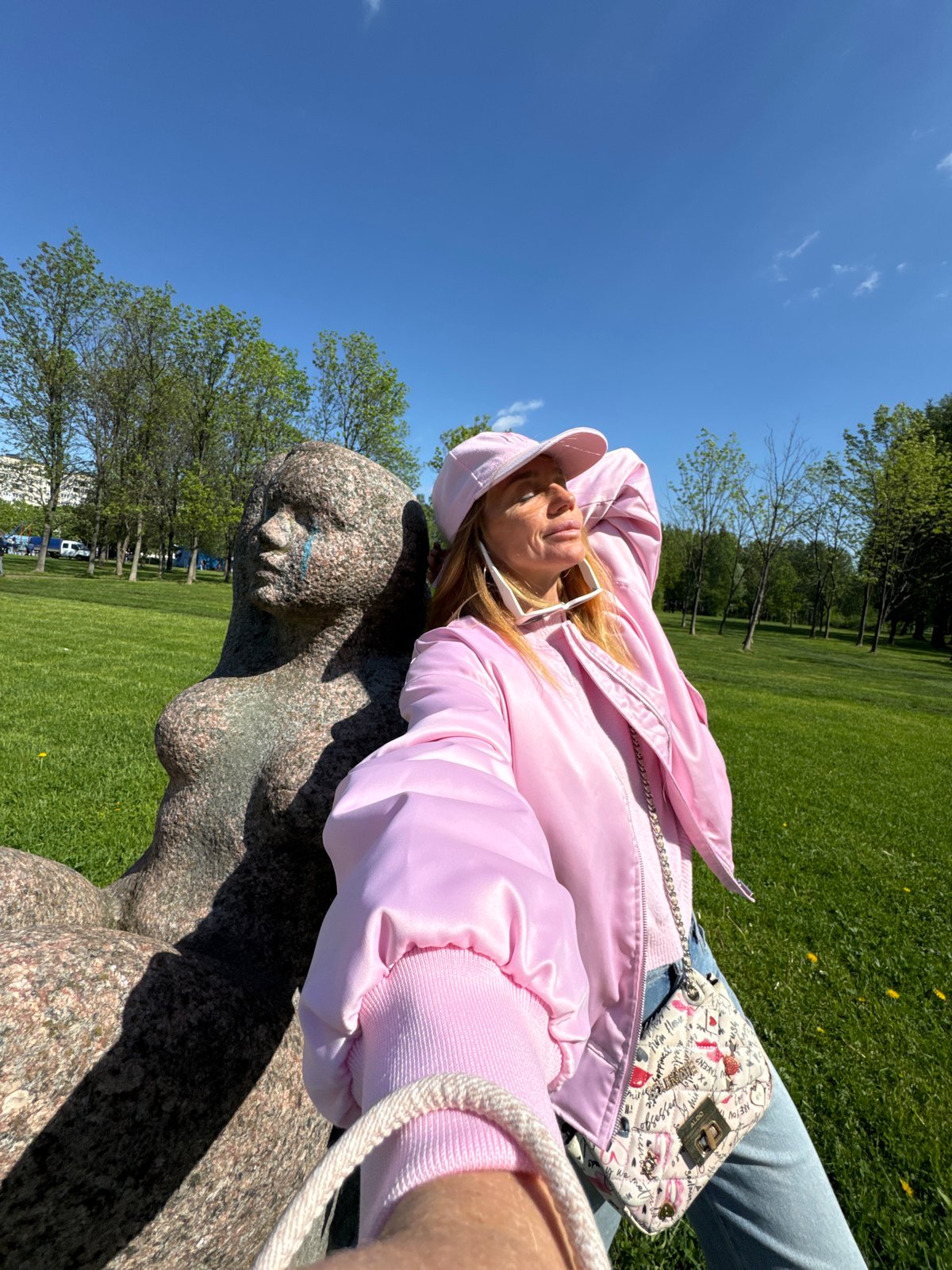 Tourist poses with nude sculptures in Saint Petersburg park