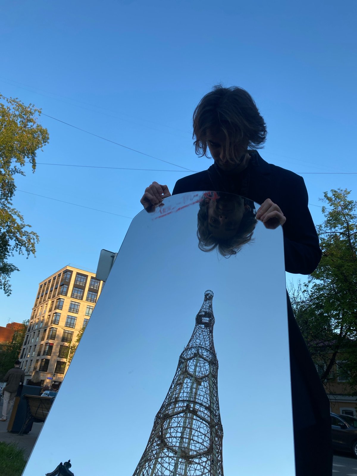 Person captures Shukhov Tower reflection in mirror in Moscow