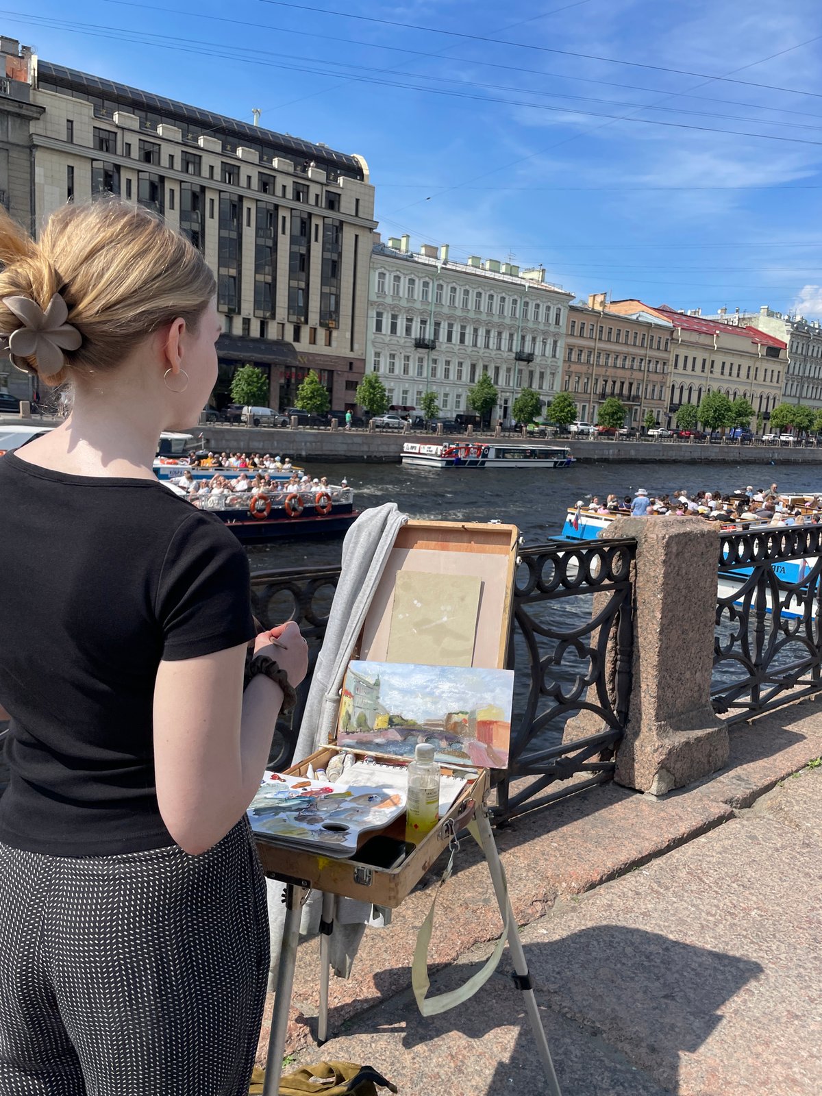 Artist paints canal scenes during morning in Saint Petersburg