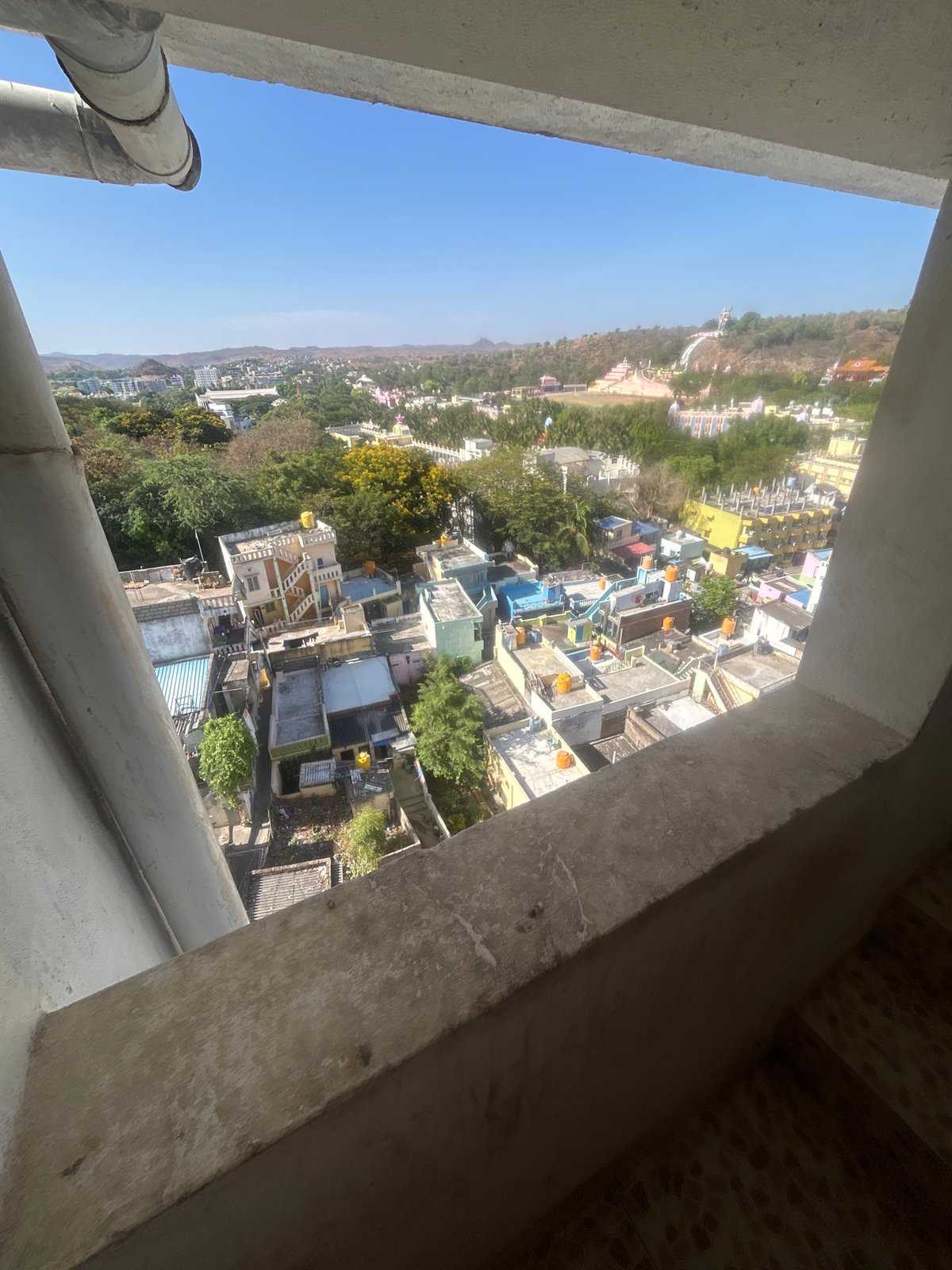 Elevated view captured of Puttaparthi cityscape transitioning to forest