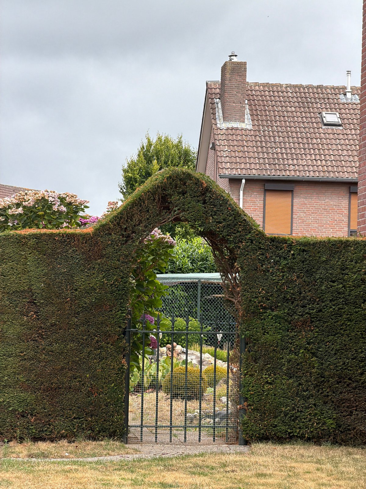 Tidy gardens and quiet streets in Melick on a grey morning