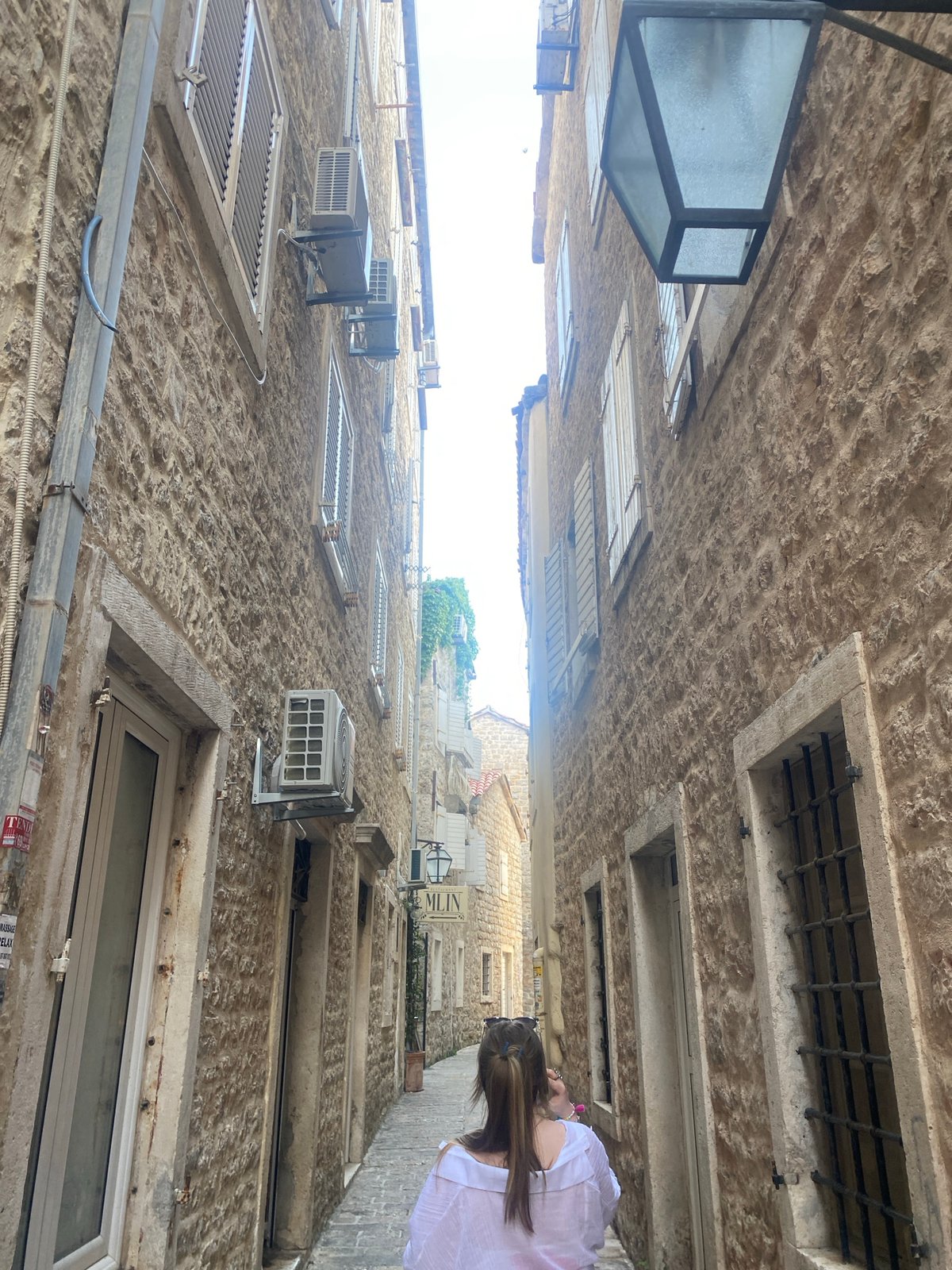 Tourist documents afternoon stroll through Budva's historic old town
