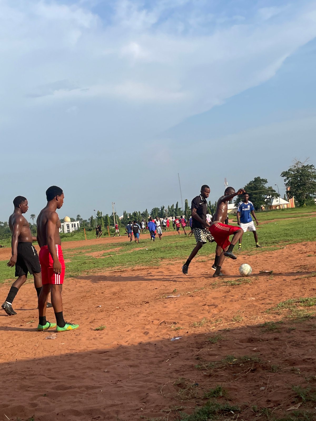 Casual soccer match on dirt field in Ogbogbo, Nigeria