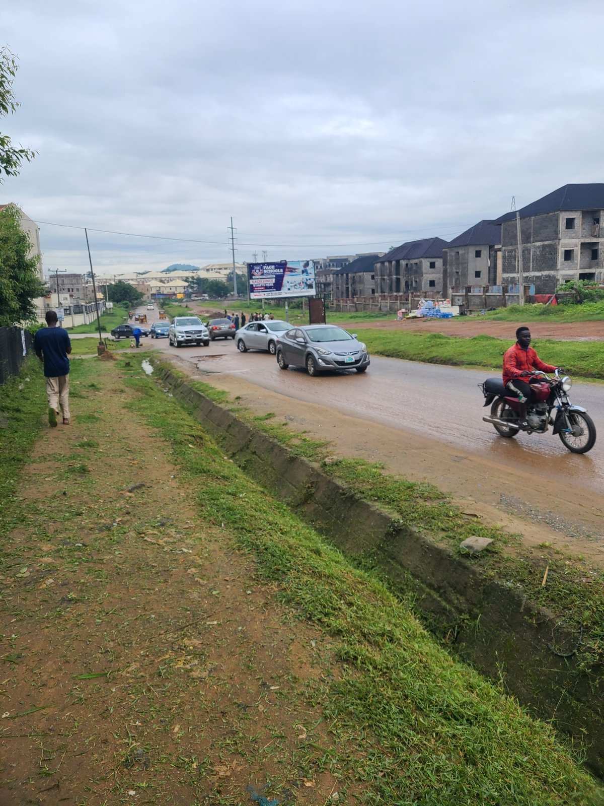 Wet streets and dirt paths on a grey morning in Abuja