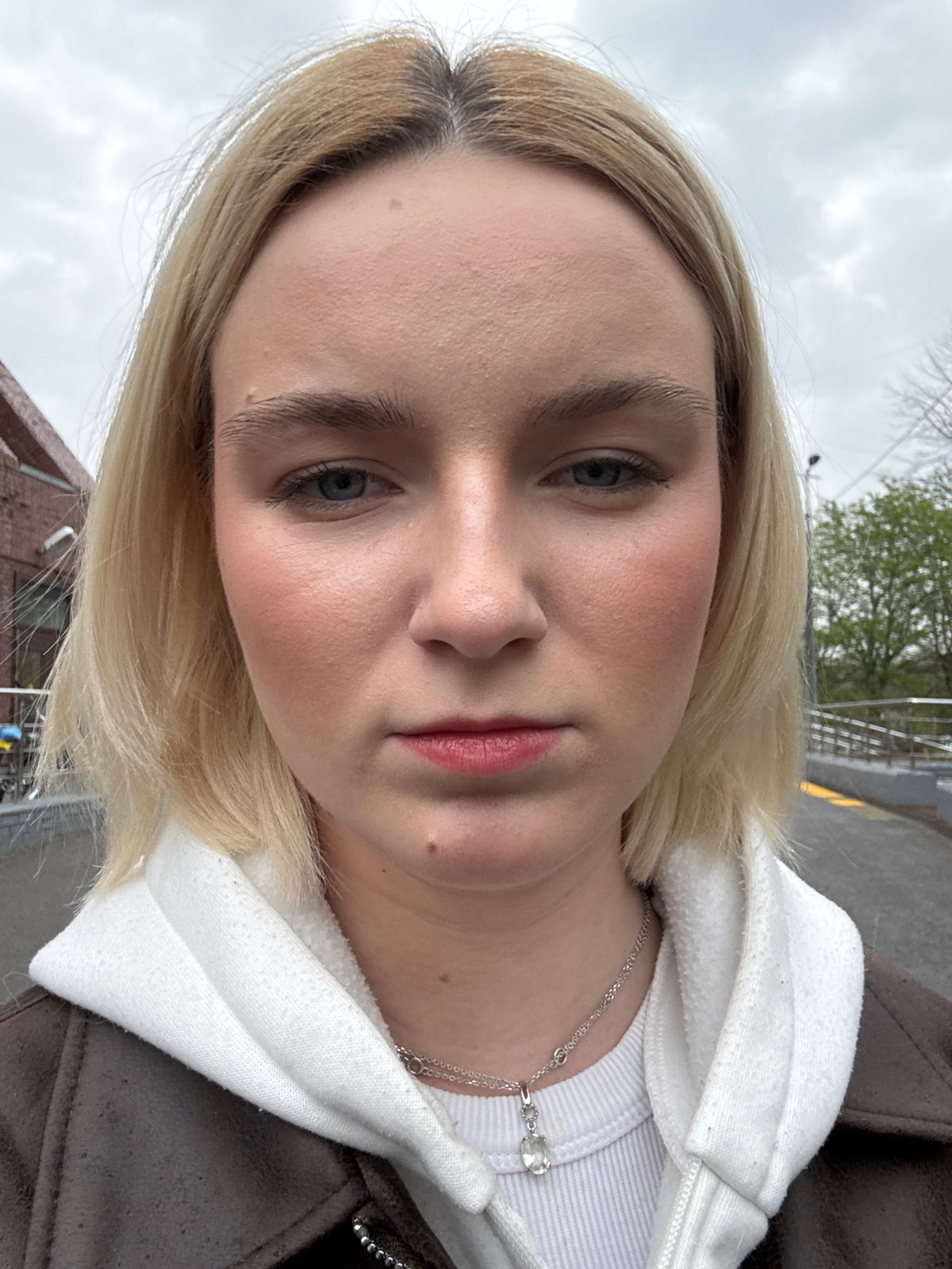 Woman takes selfies on cloudy afternoon in Saint Petersburg