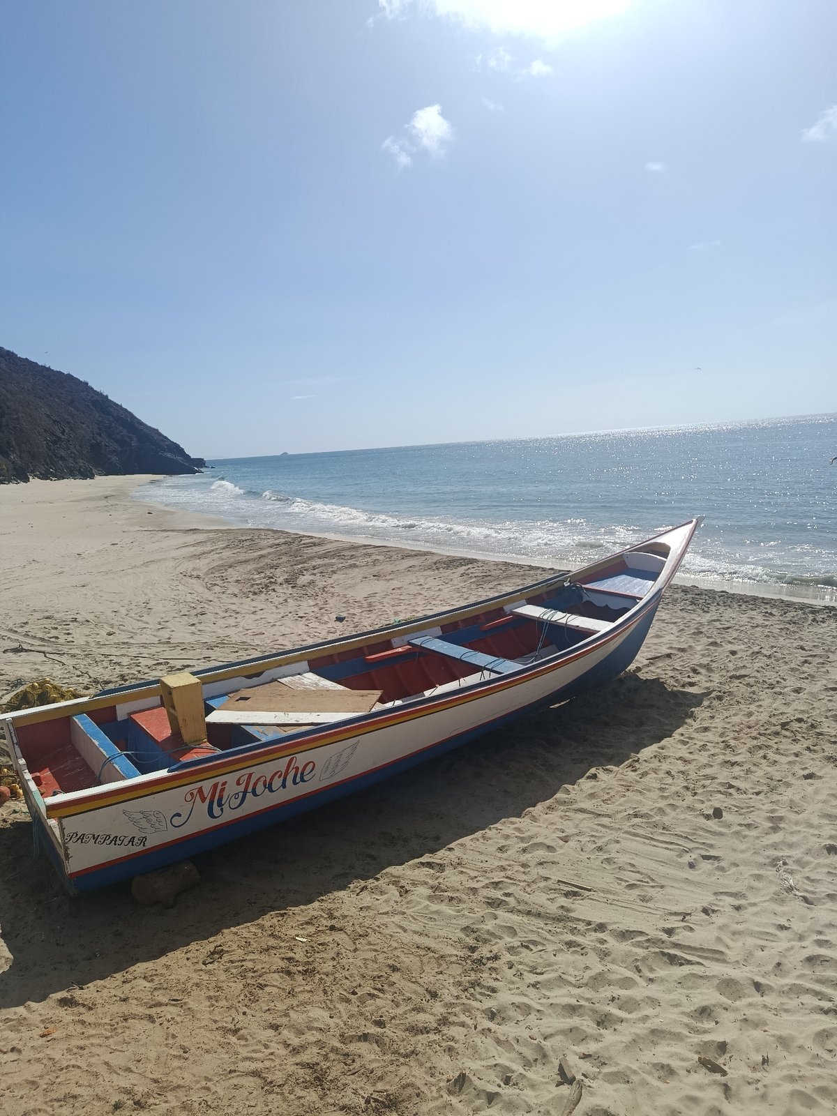 Visitors document colorful fishing boats at Guayacán beach
