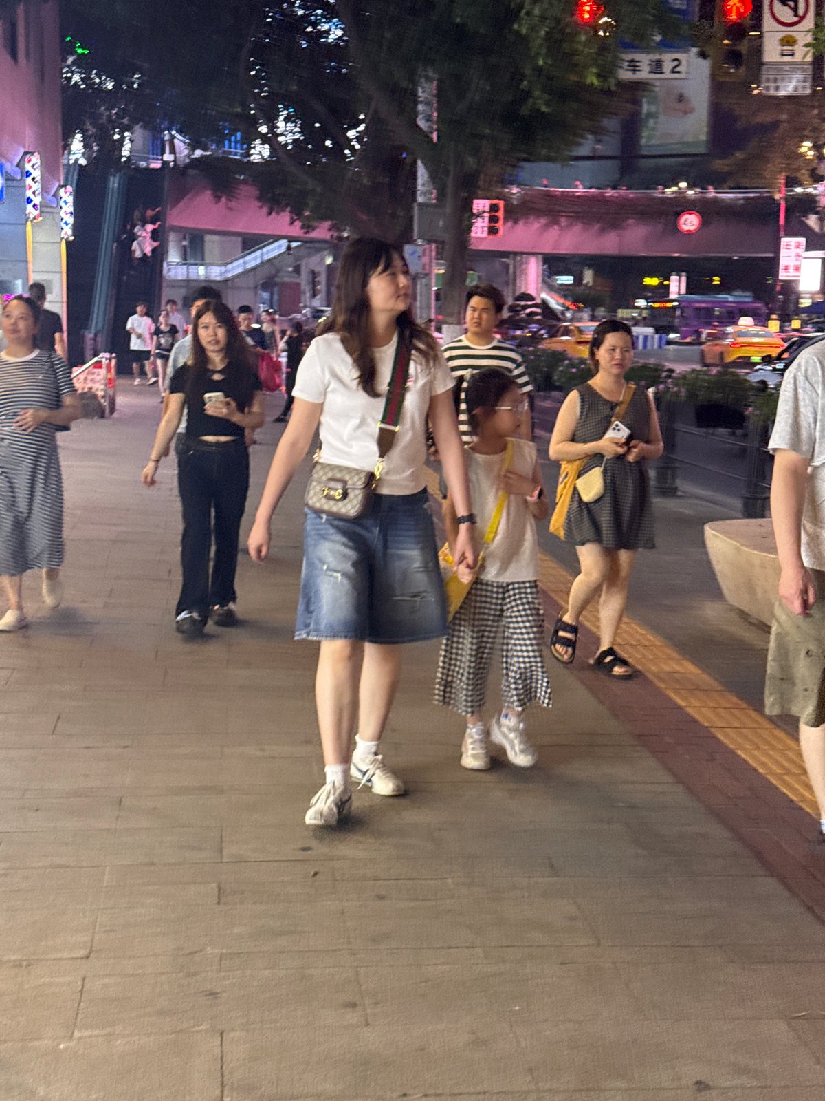 Evening foot traffic on a neon-lit Chongqing pedestrian street