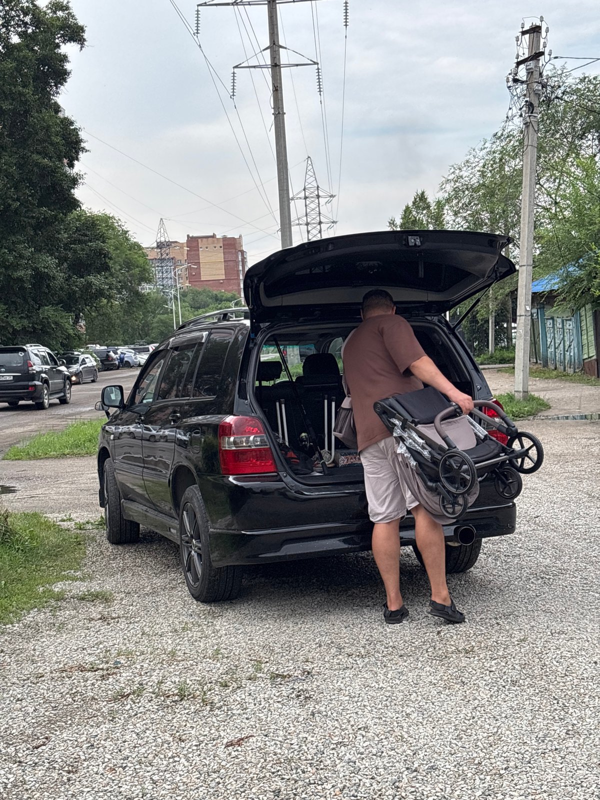 Stroller loaded into SUV trunk on gravel in Blagoveshchensk