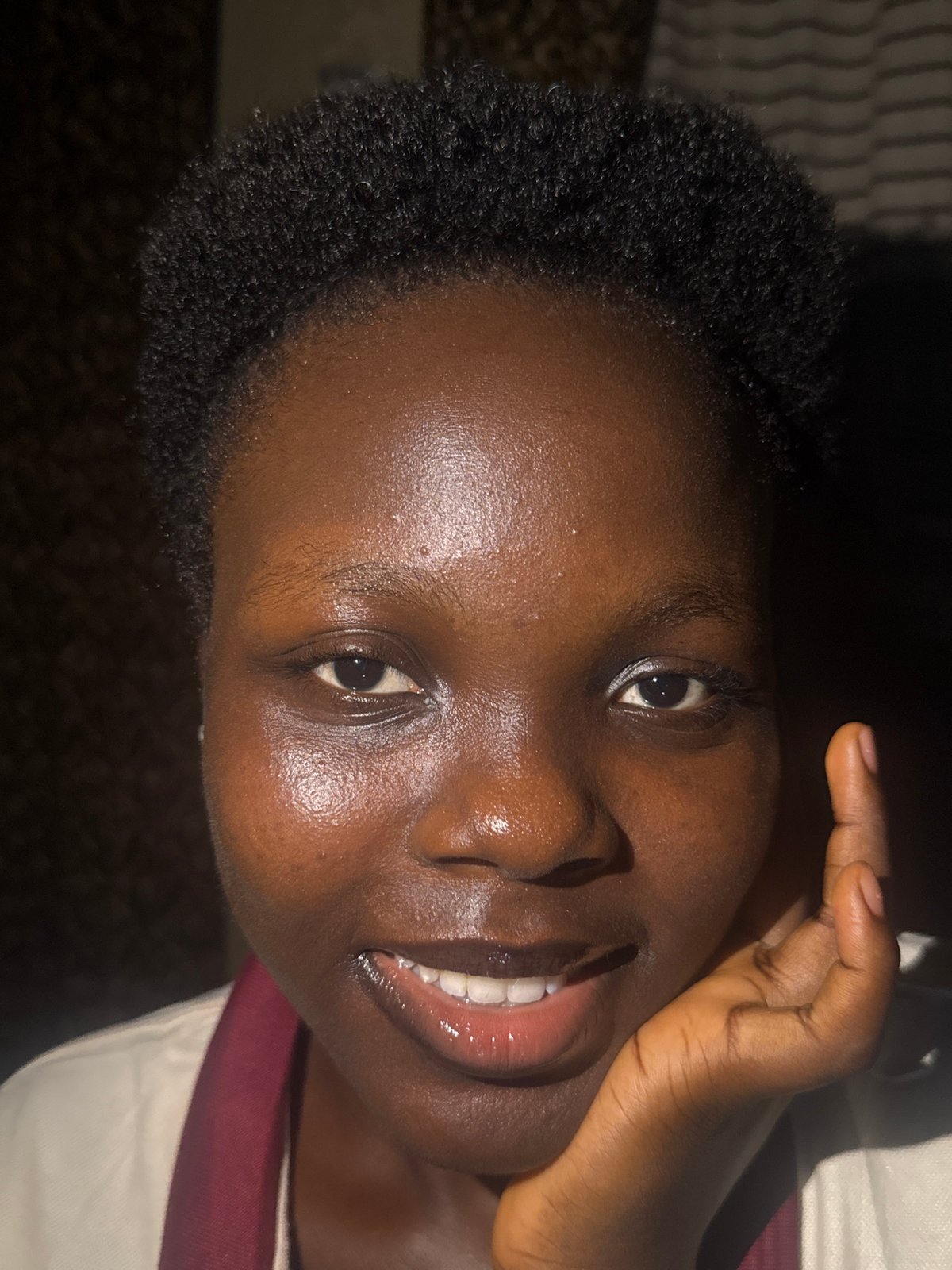 Young woman photographed writing and smiling in Onitsha, Nigeria