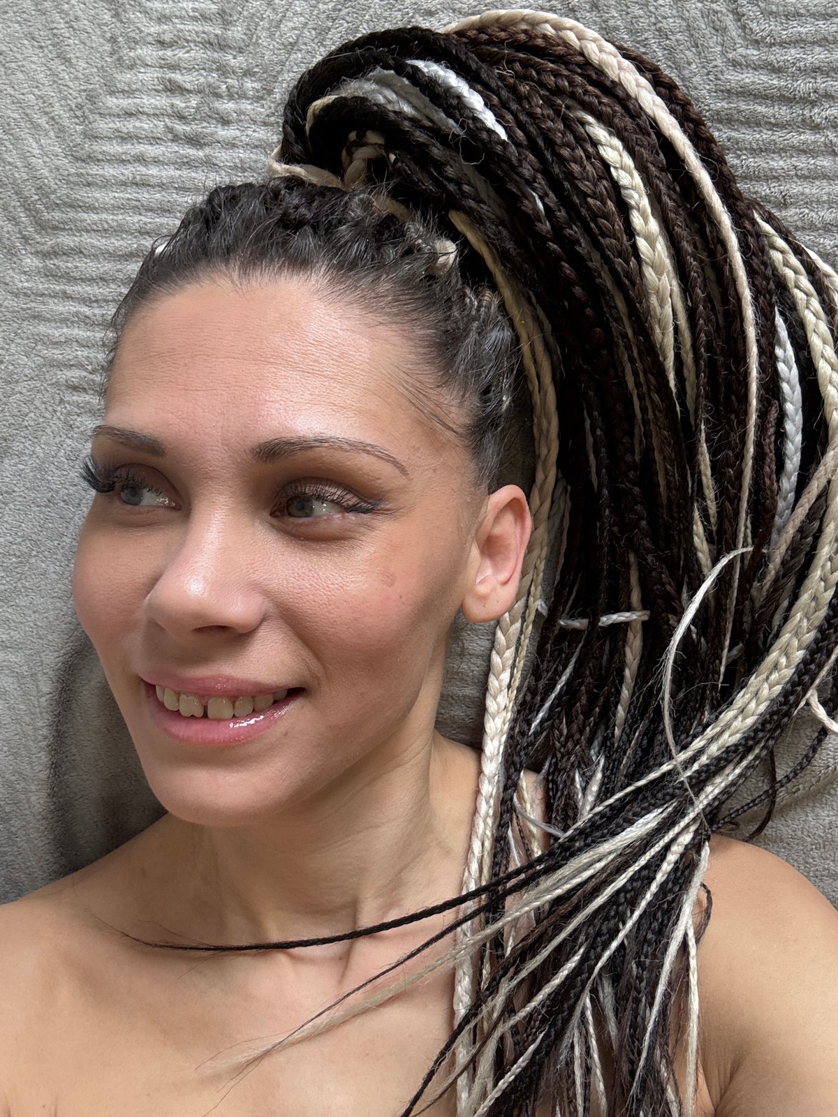 Person with braided hair rests on fabric surfaces