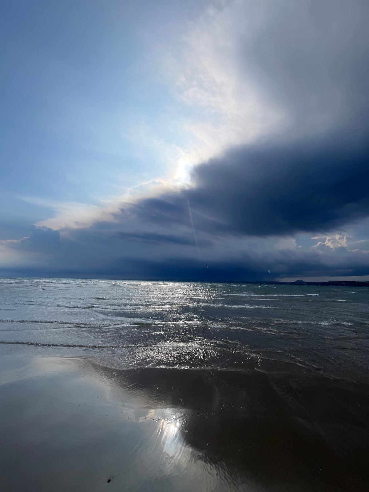 Kitesurfers rig up on Mũi Né beach under stormy skies