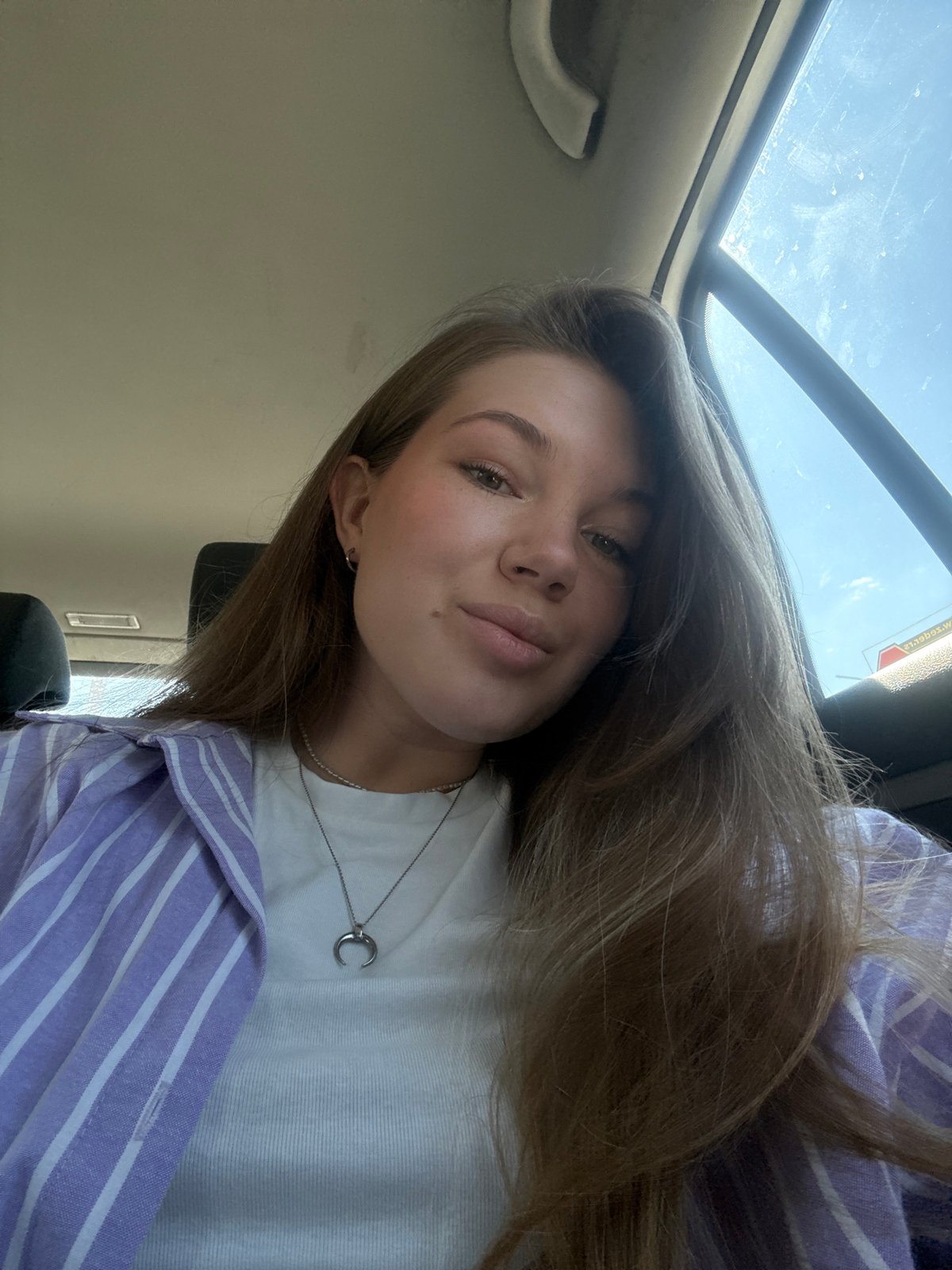 Woman takes selfies in car in Belgrade morning