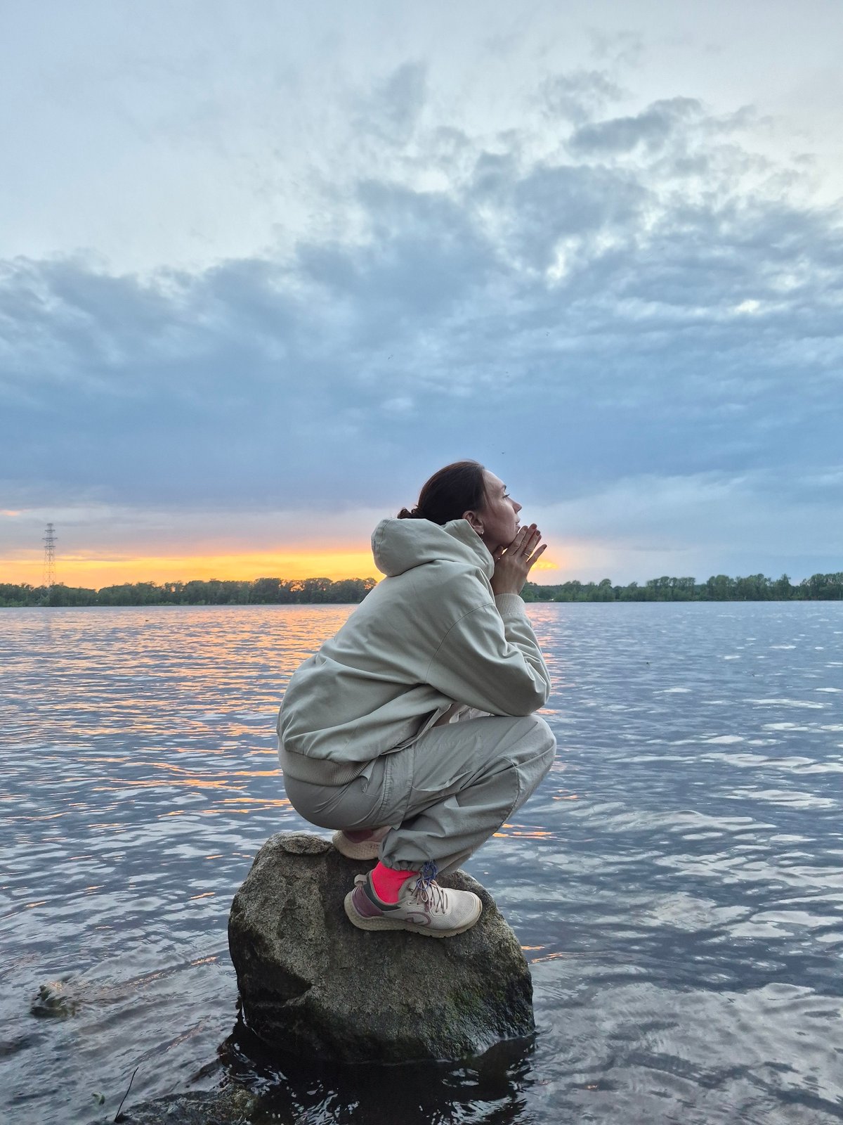 Woman enjoys sunset moment by water's edge