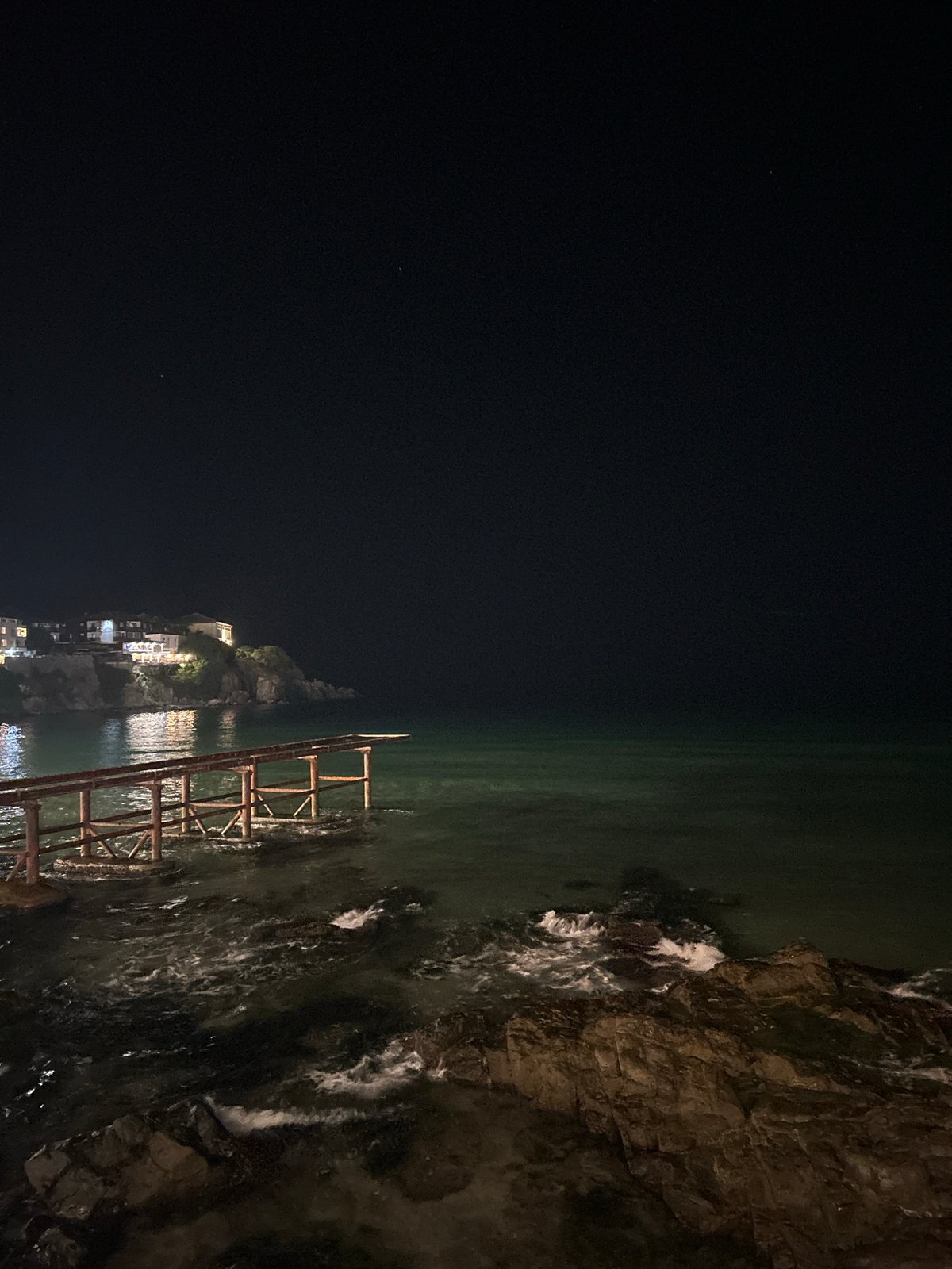 Sozopol's lit coastline meets the Black Sea at night