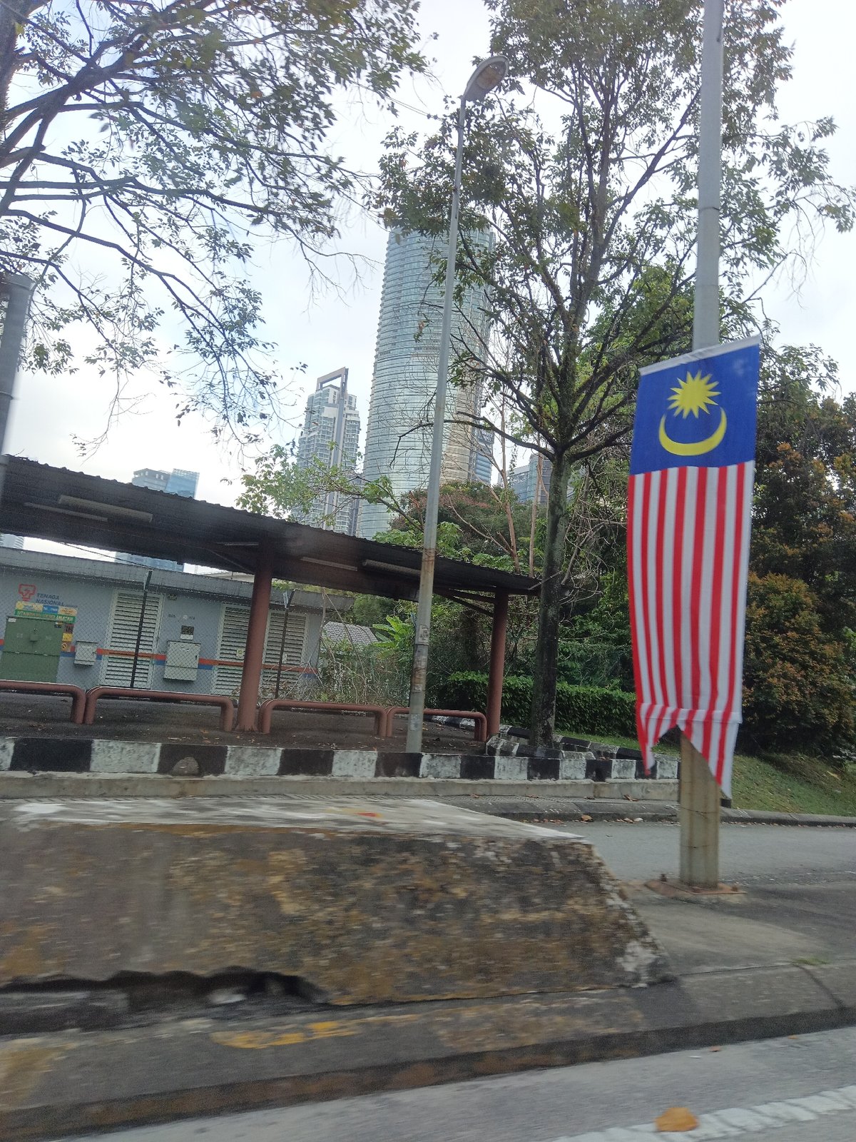 Driving through KL with national landmarks and flags in view