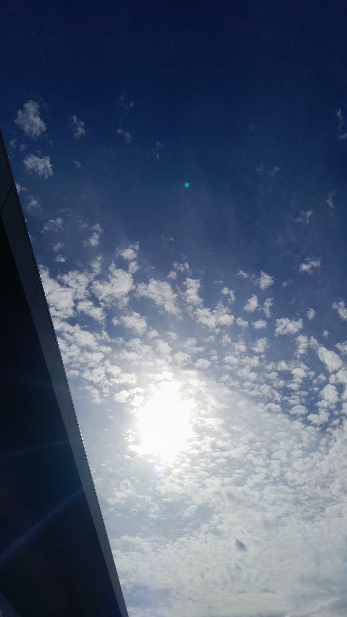 Midday sun and clouds over Kraków, shot from street level