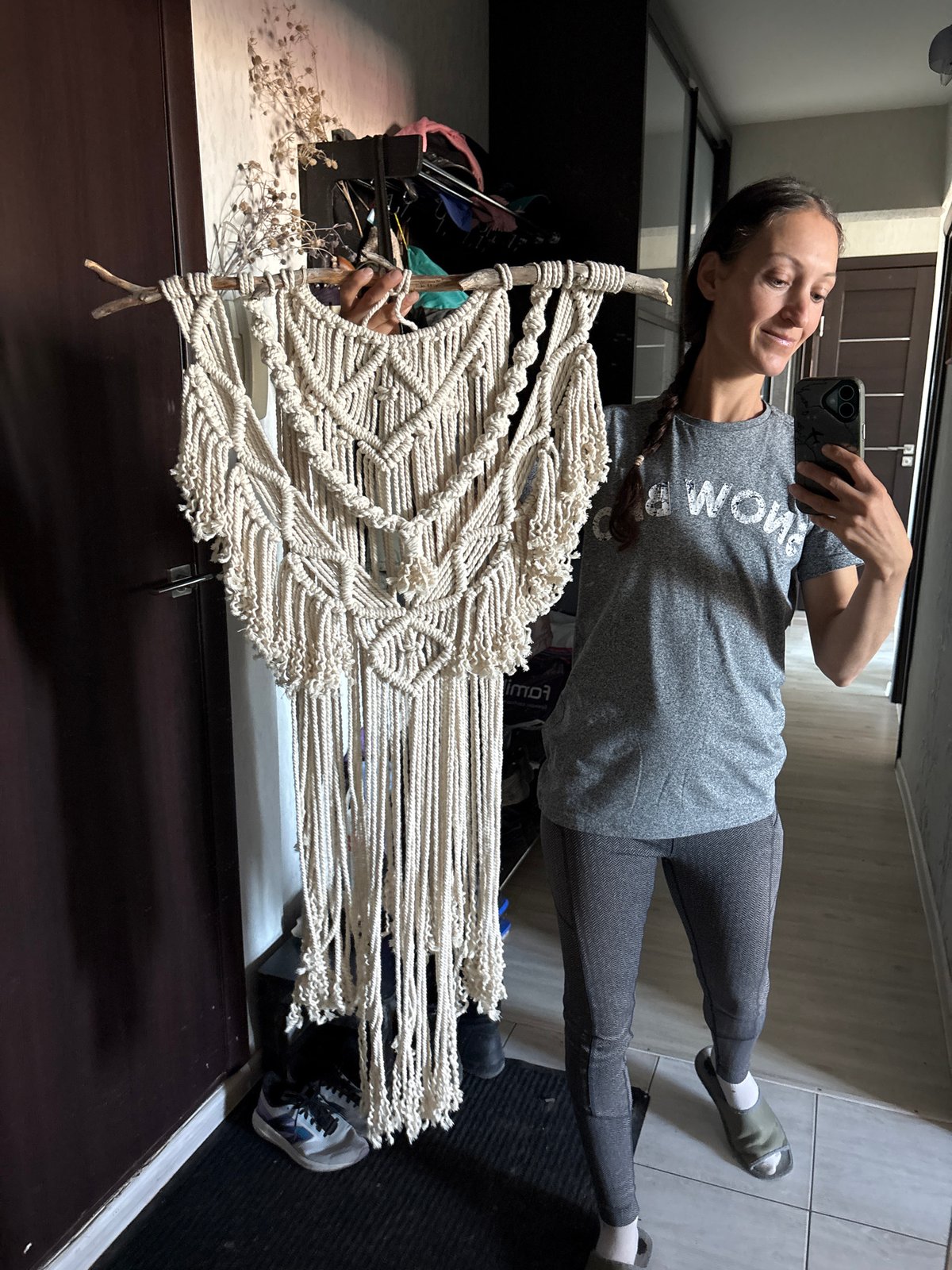 Woman displays handmade macrame artwork in Ulyanovsk home