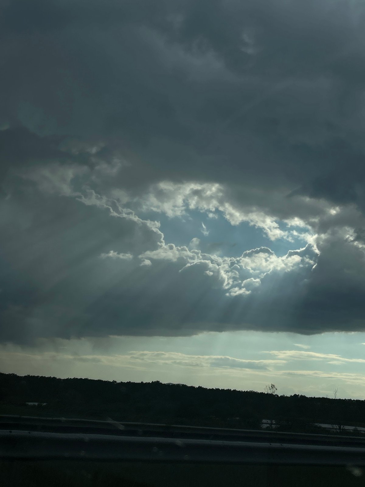 Sunbeams pierce dark clouds over Bulgarian village