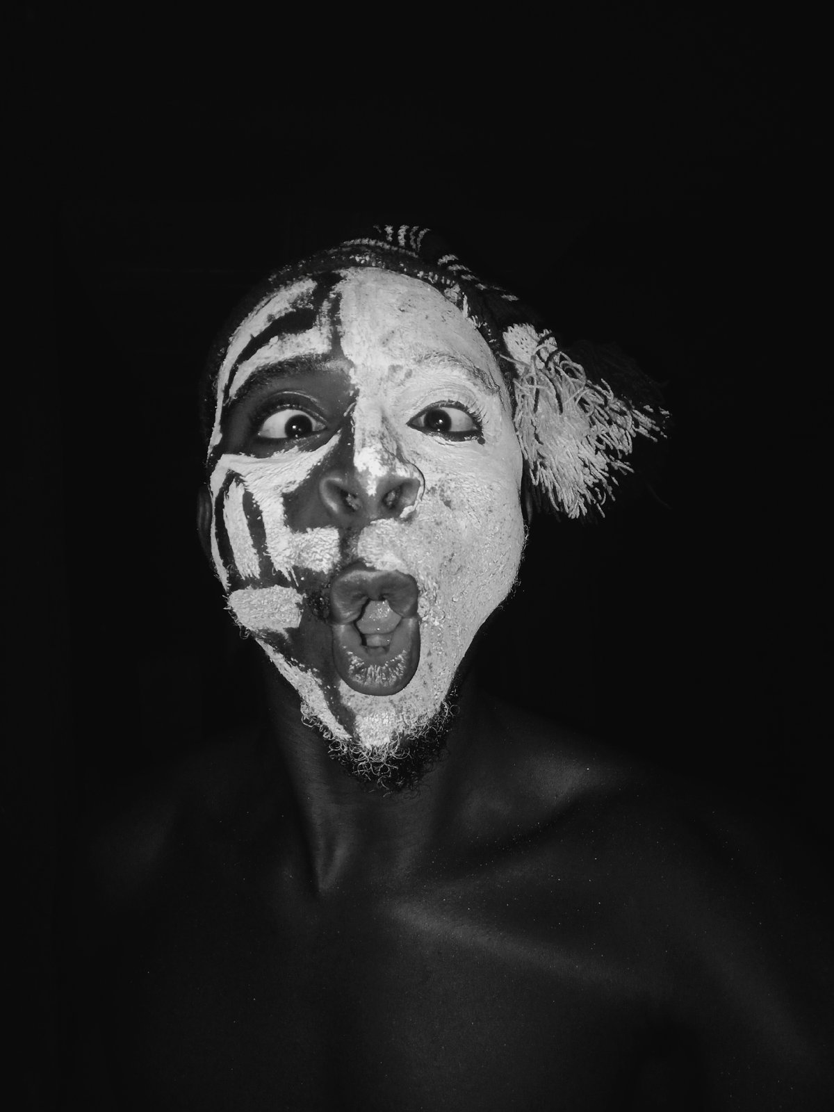 Face-painted performer photographed in multiple poses across Onitsha, Nigeria