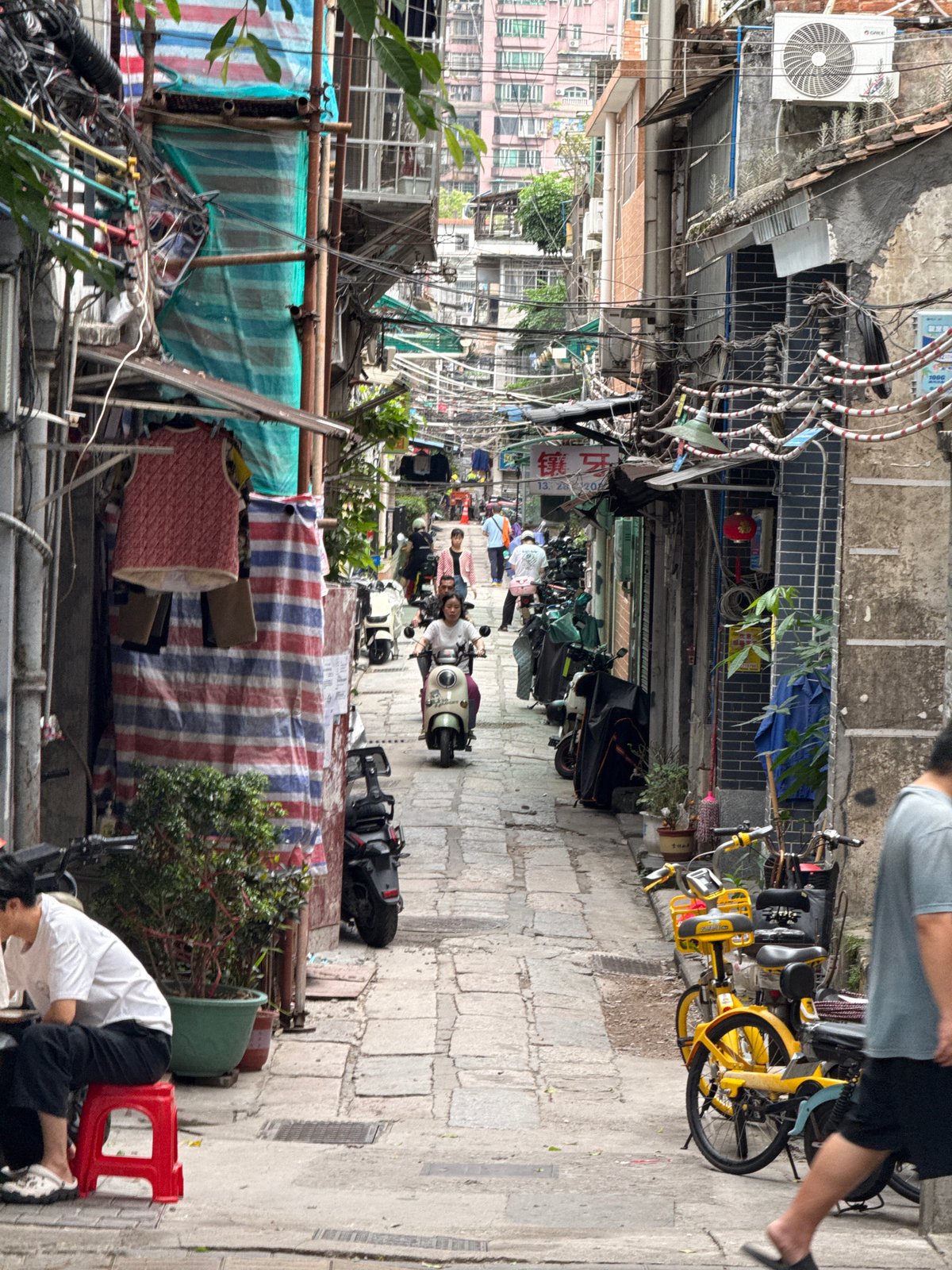Motorbikes crowd narrow stone alley in Liwan District