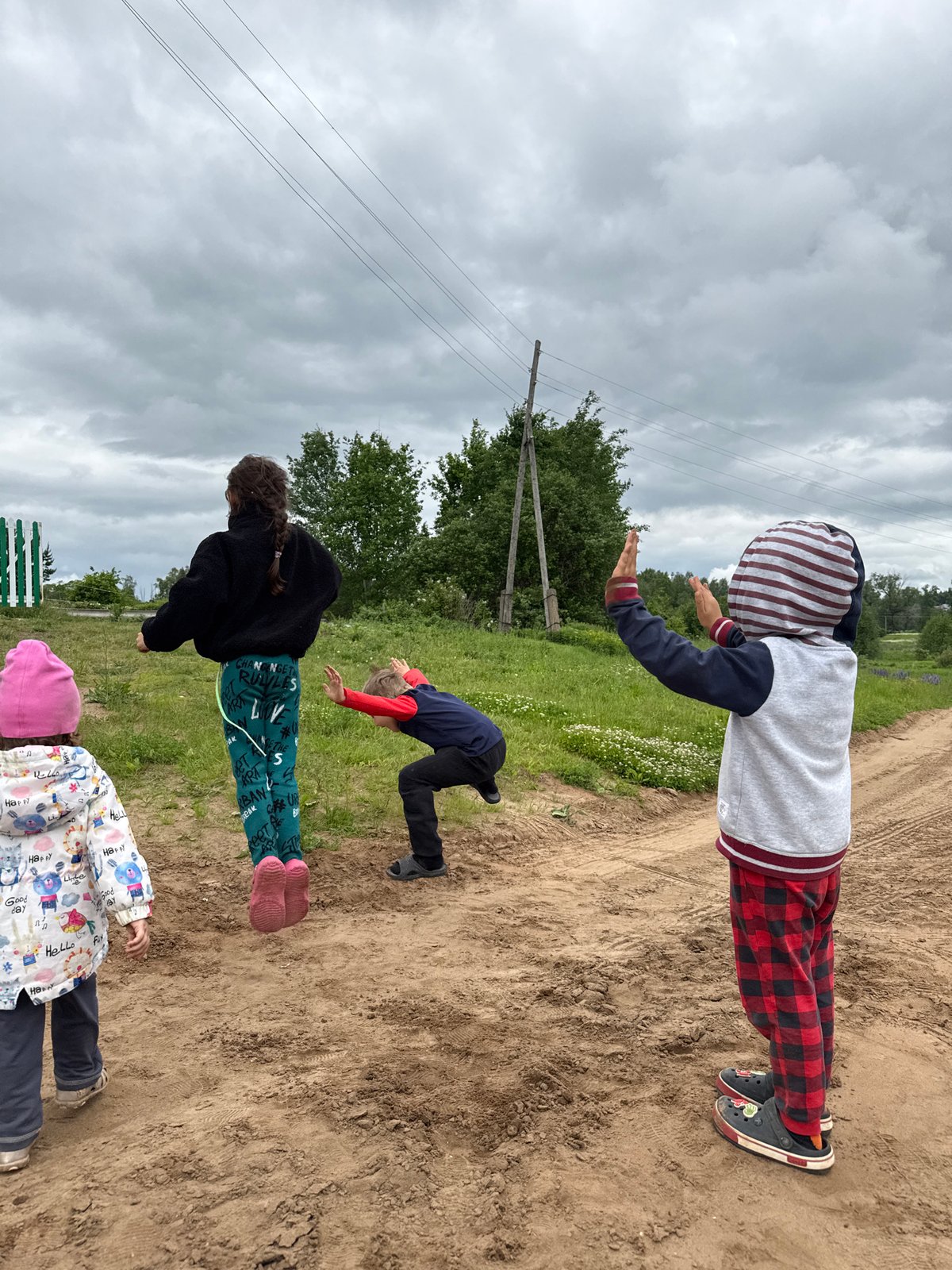 Children play and jump on dirt roads in rural Russia