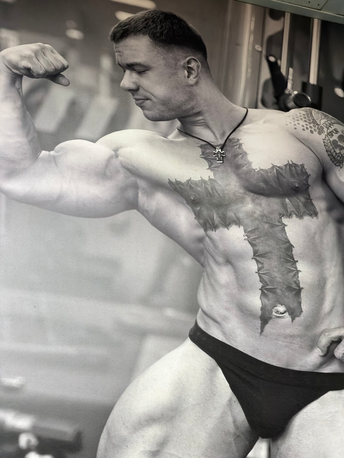 Tattooed man exercises at gym facility in Izhevsk