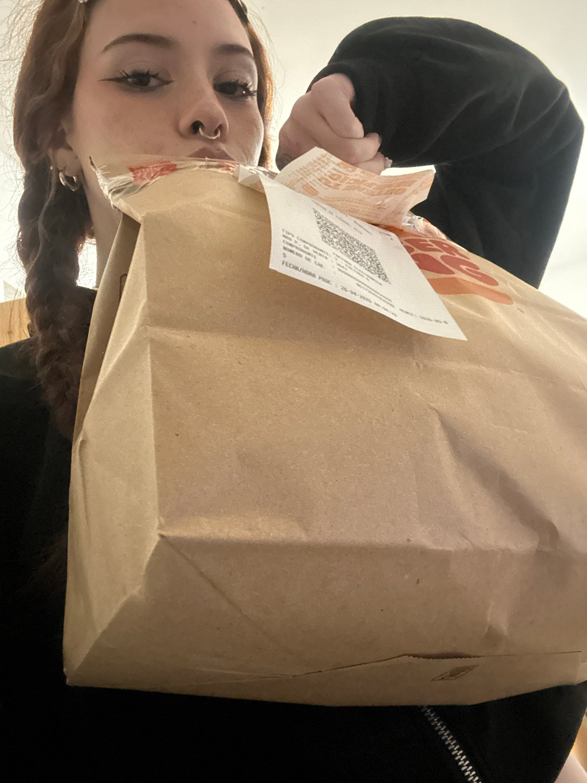 Person with piercings holds receipt bag in Buenos Aires