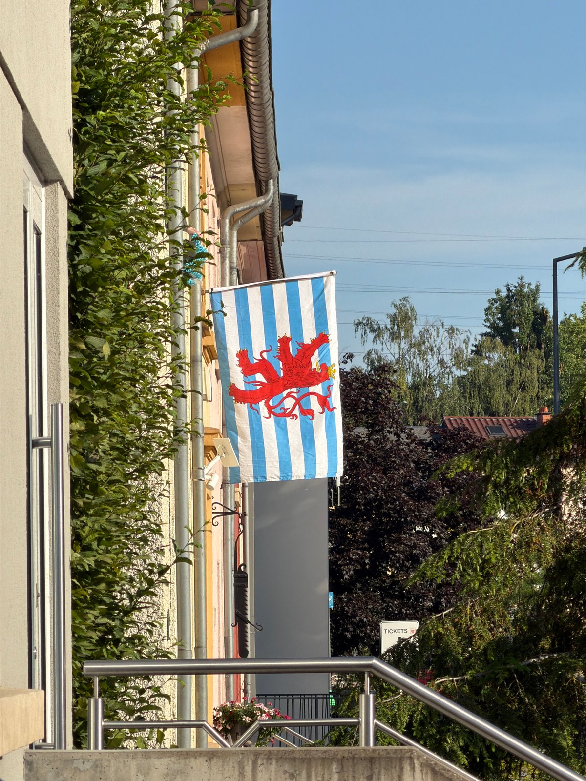 Flags flying on a pastel building in Esch-sur-Alzette