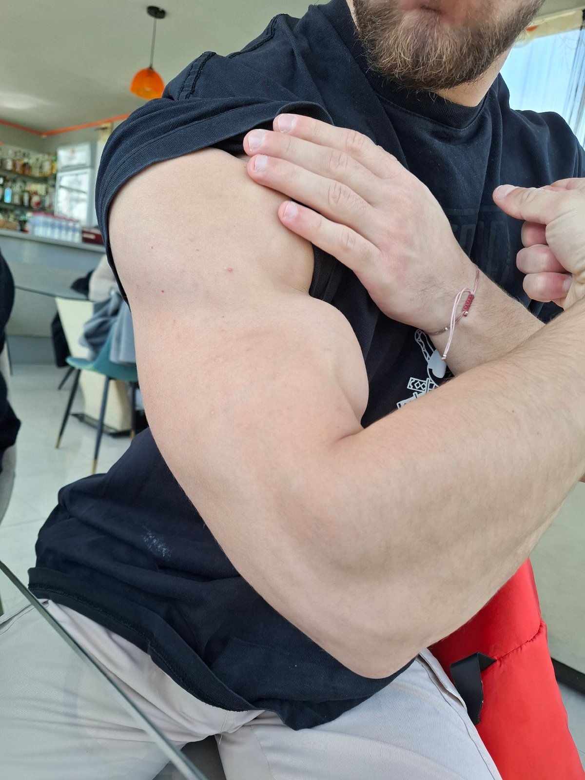 Person flexes bicep in red chair, Tsarevo Bulgaria