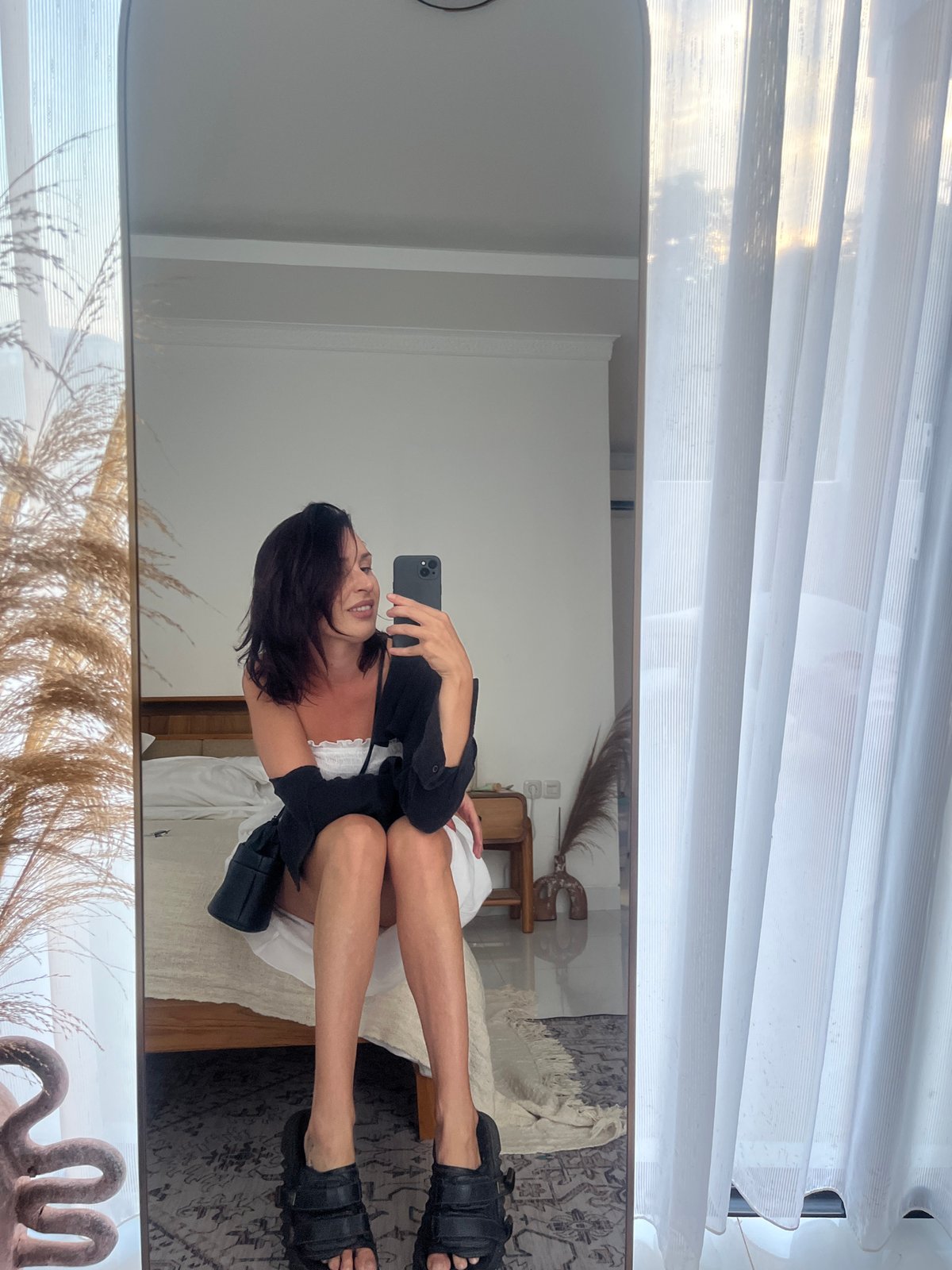 Woman takes mirror selfie in Kuta Selatan bedroom