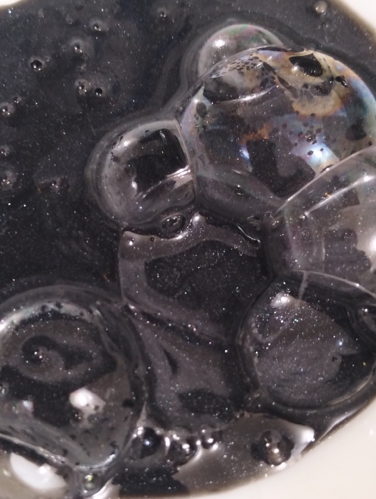 Mysterious bubbling black liquid observed with iridescent properties