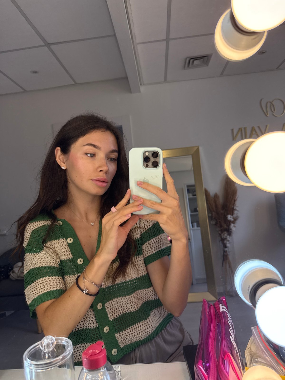 Mirror selfie in a Ramat Gan dressing room, striped cardigan