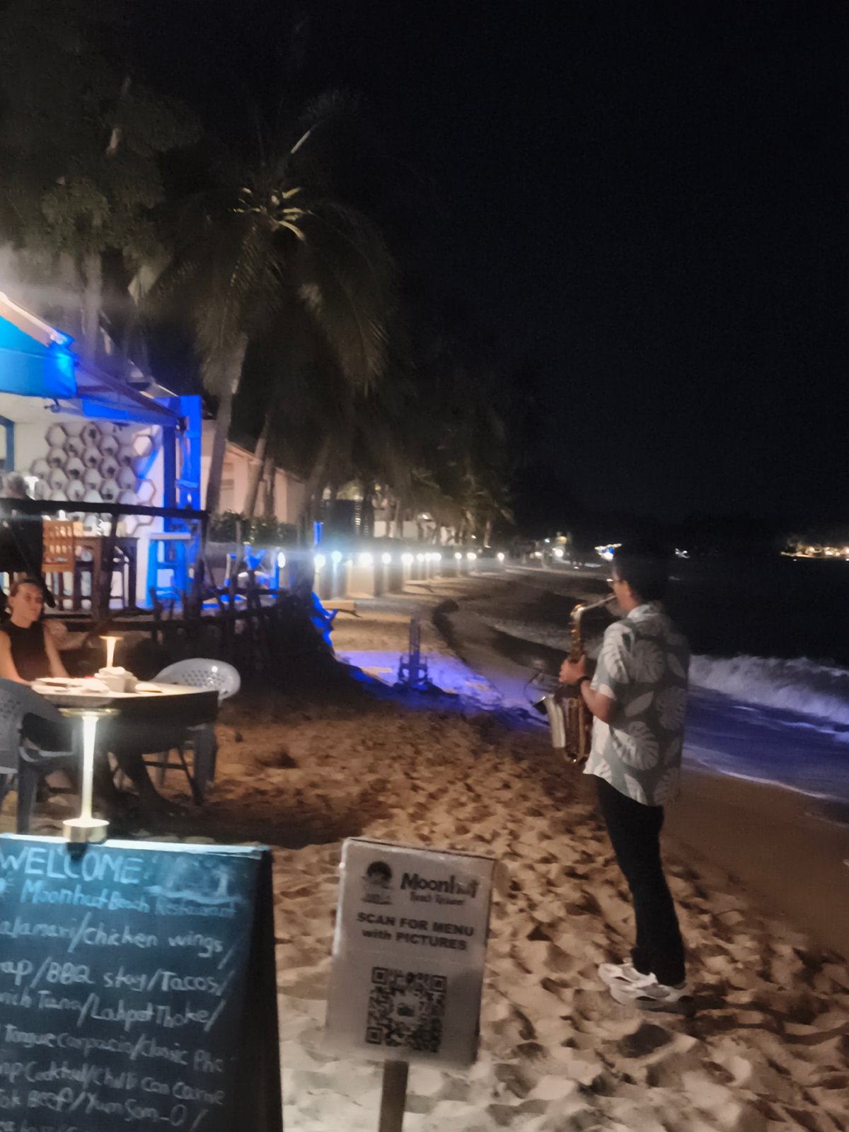 Late-night beach scene in Ko Samui with live saxophone