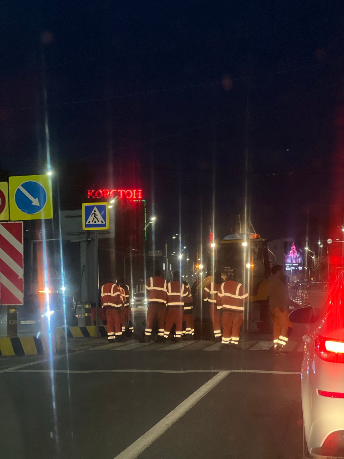 Utility workers gather on Kazan crosswalk near KORSTON sign