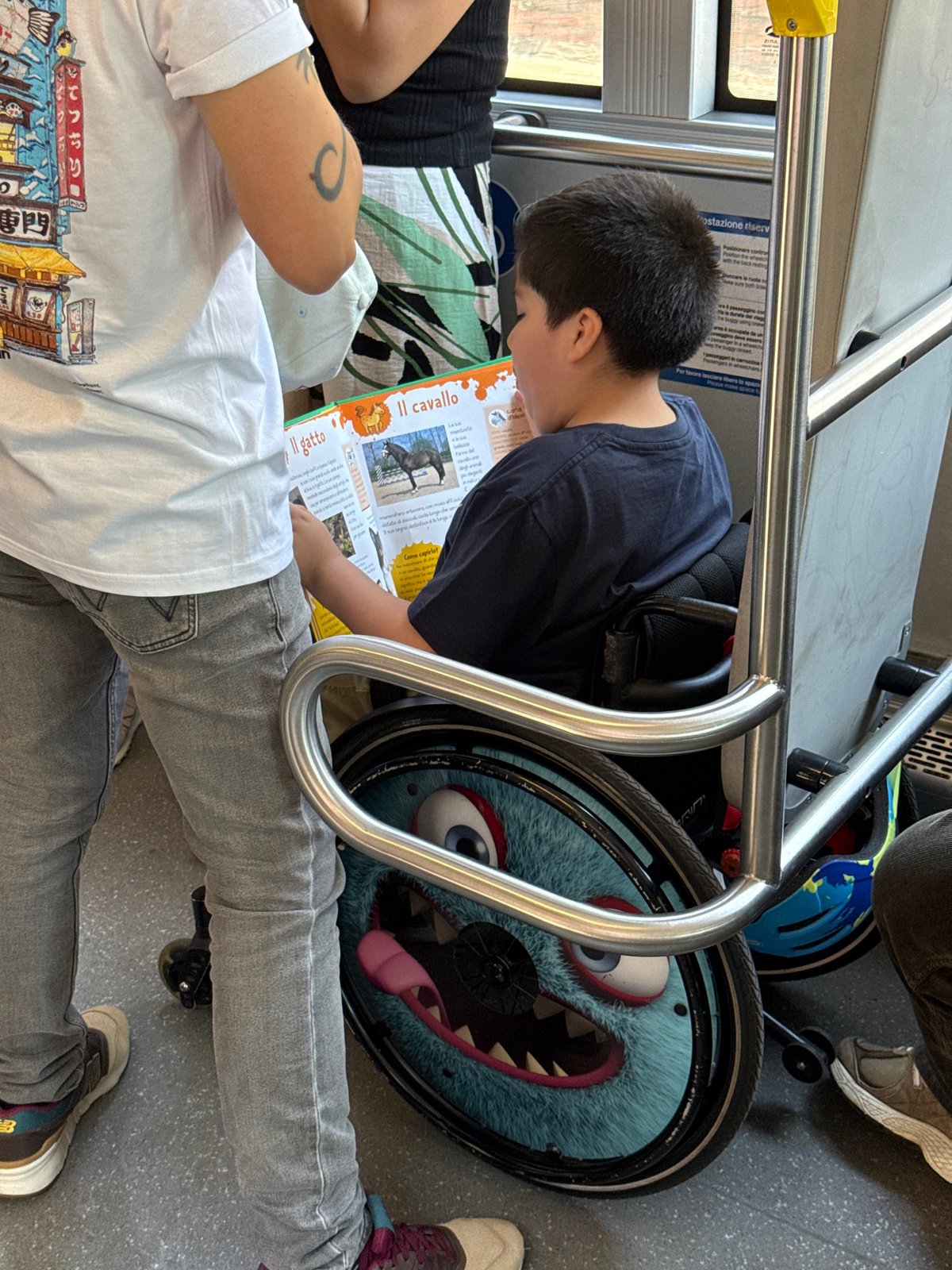 Wheelchair user reads Italian book on Milan public transport
