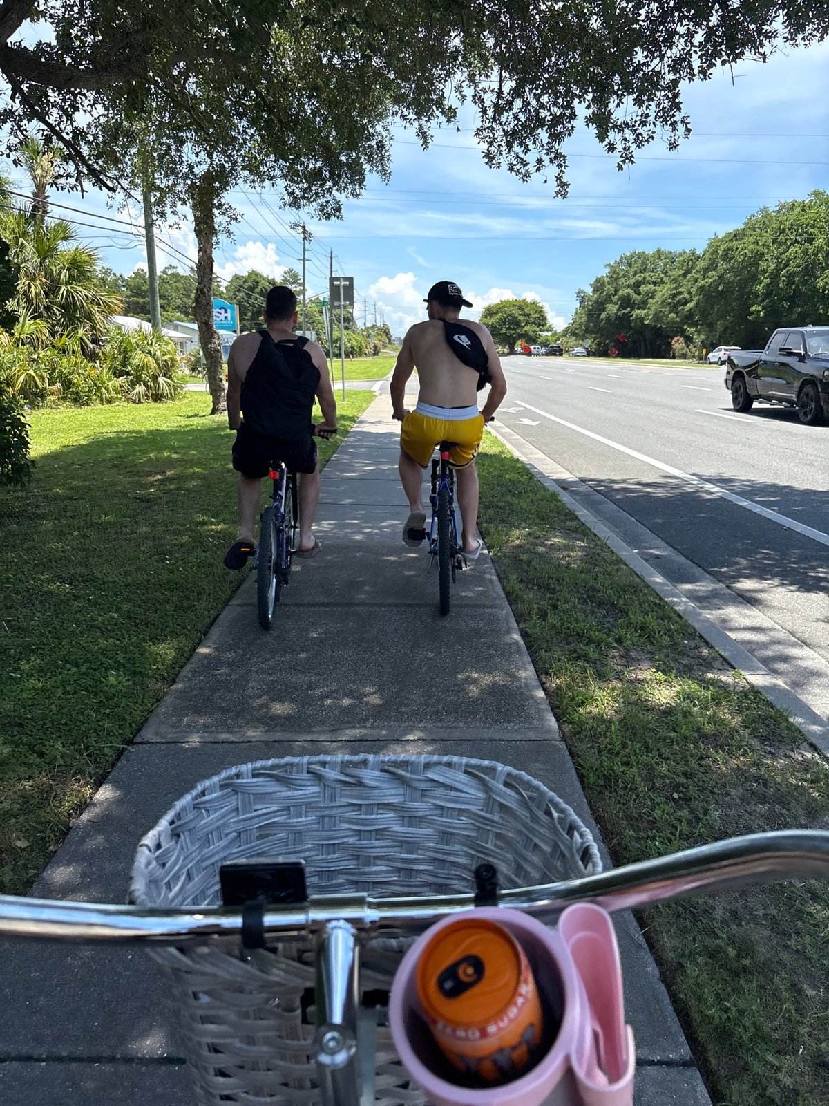 Two men cycle with Monster Energy drinks in Panama City Beach