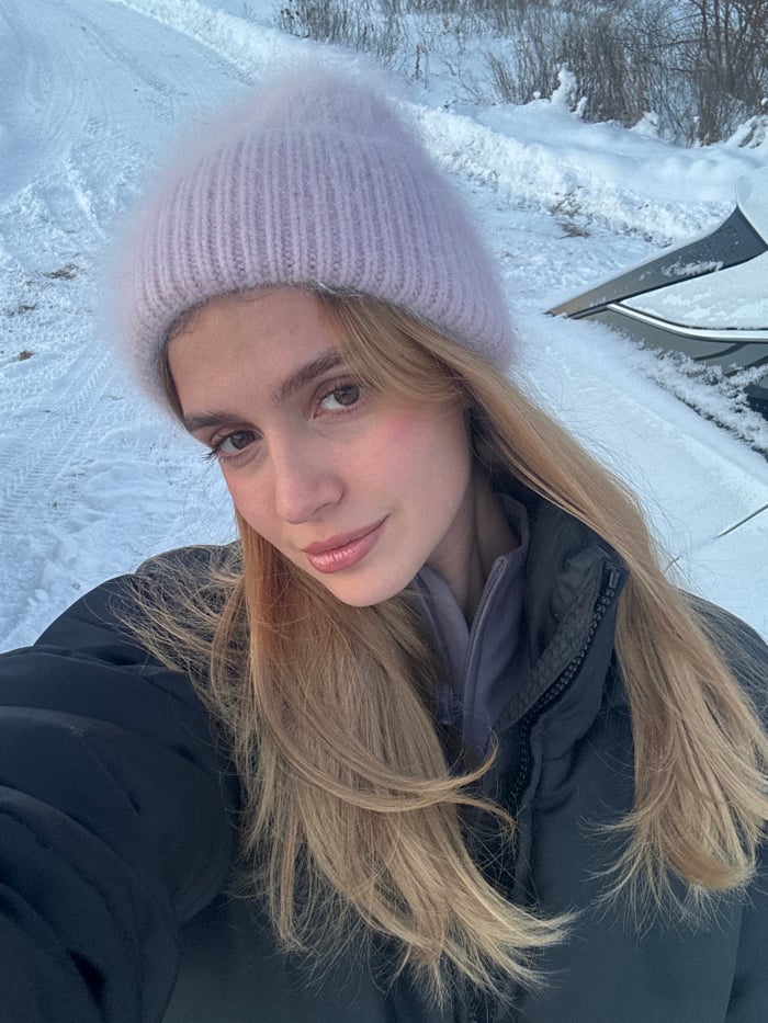 Woman photographed in snowy twilight setting during winter