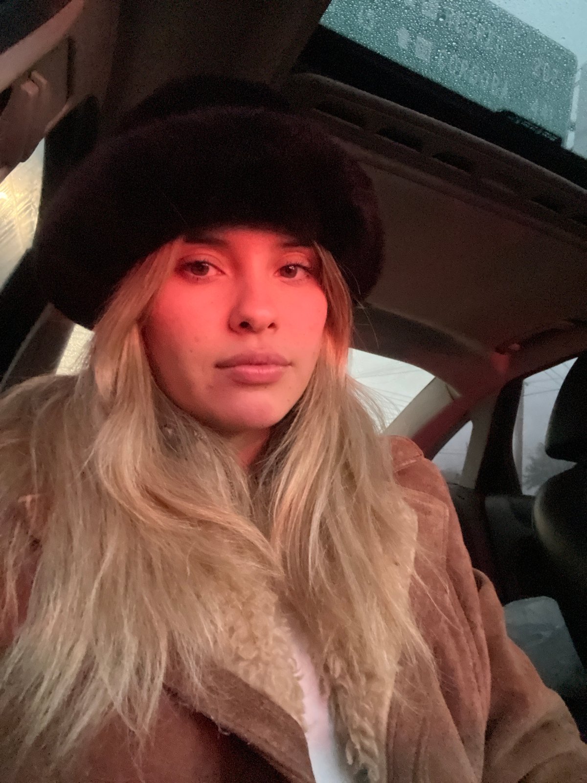 Woman takes selfies in car during rain in Argentina
