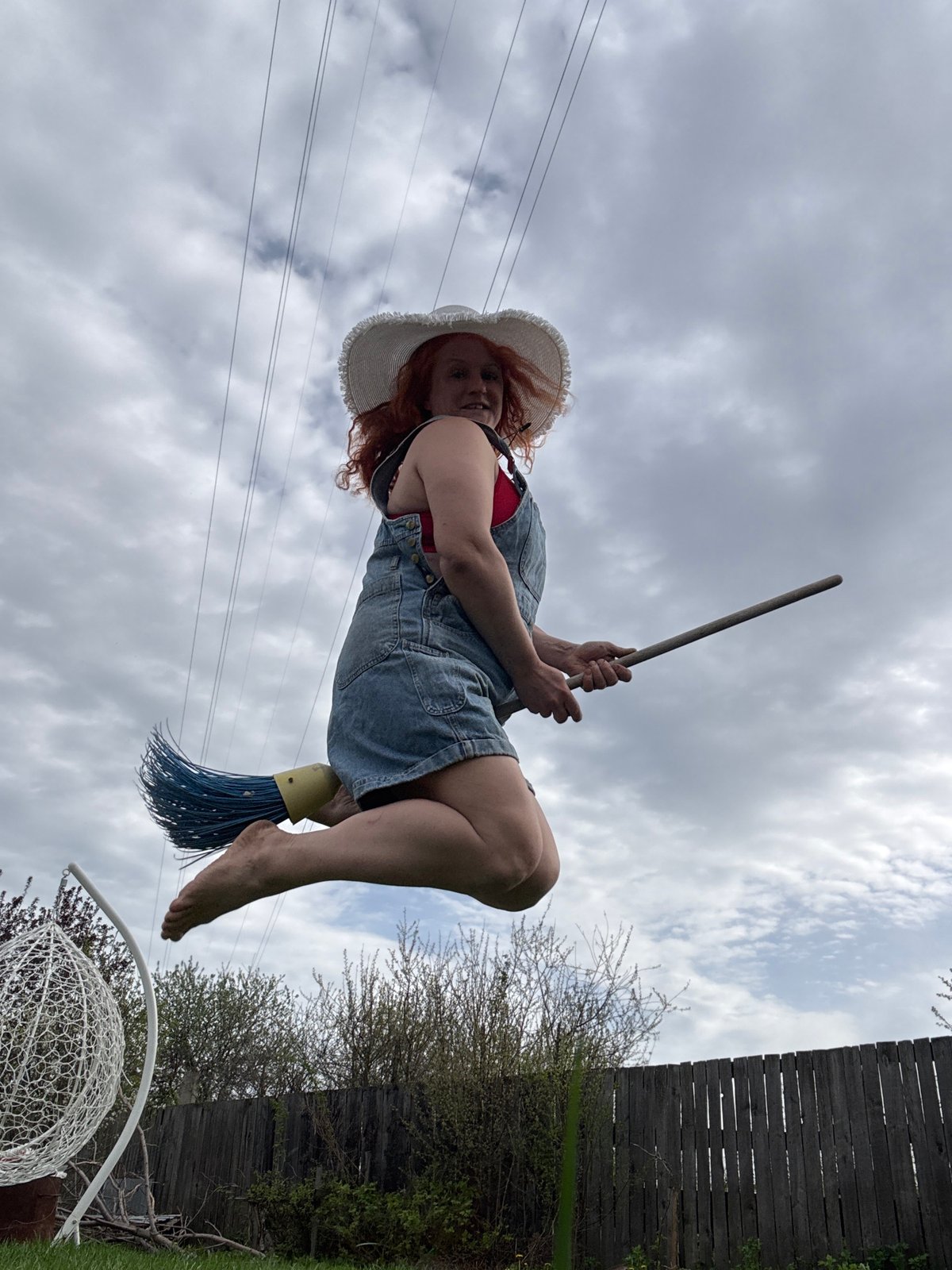 Woman in overalls poses playfully in Chaikovsky flower fields