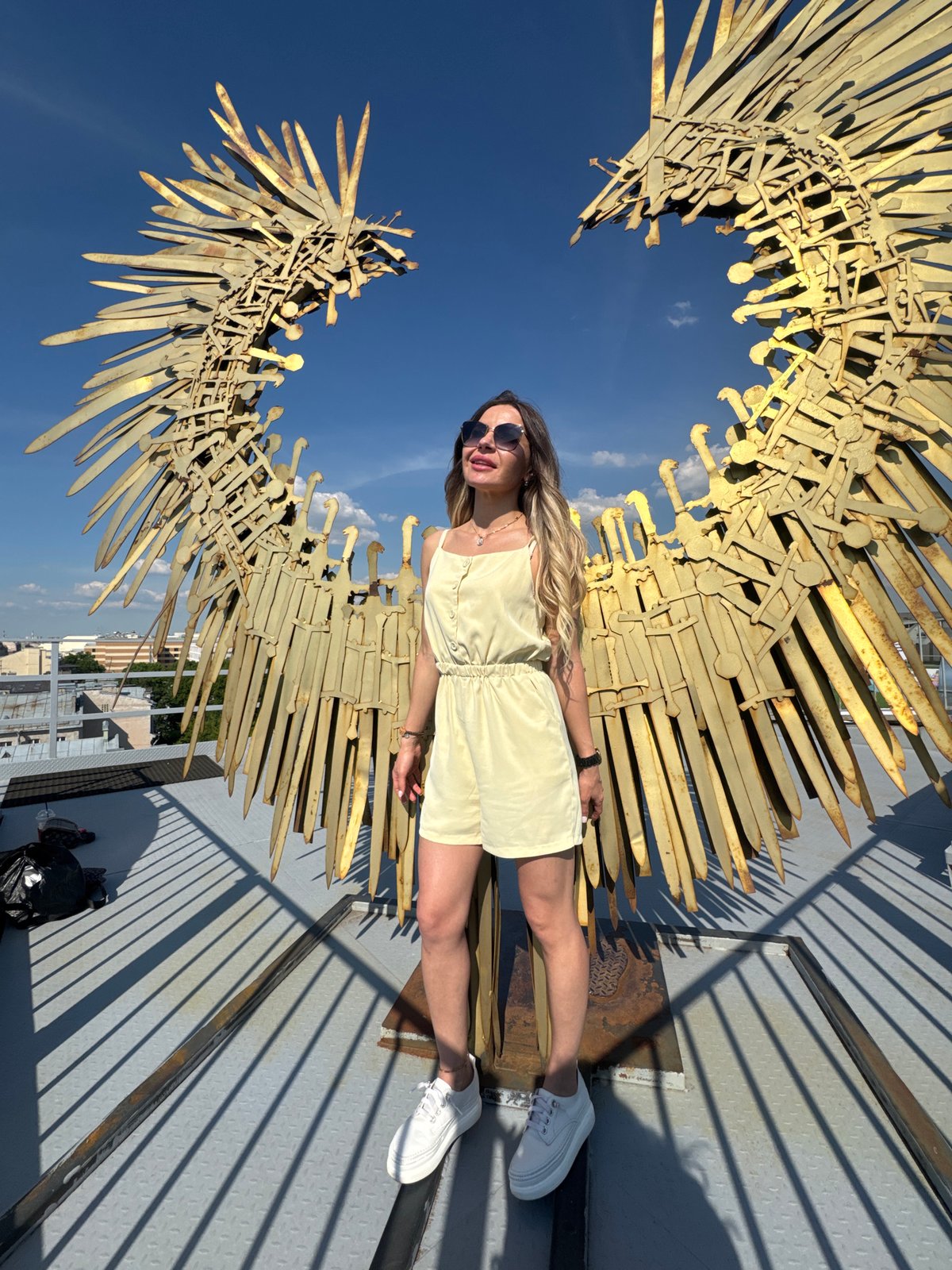 Woman poses with drinks at Saint Petersburg rooftop sculpture