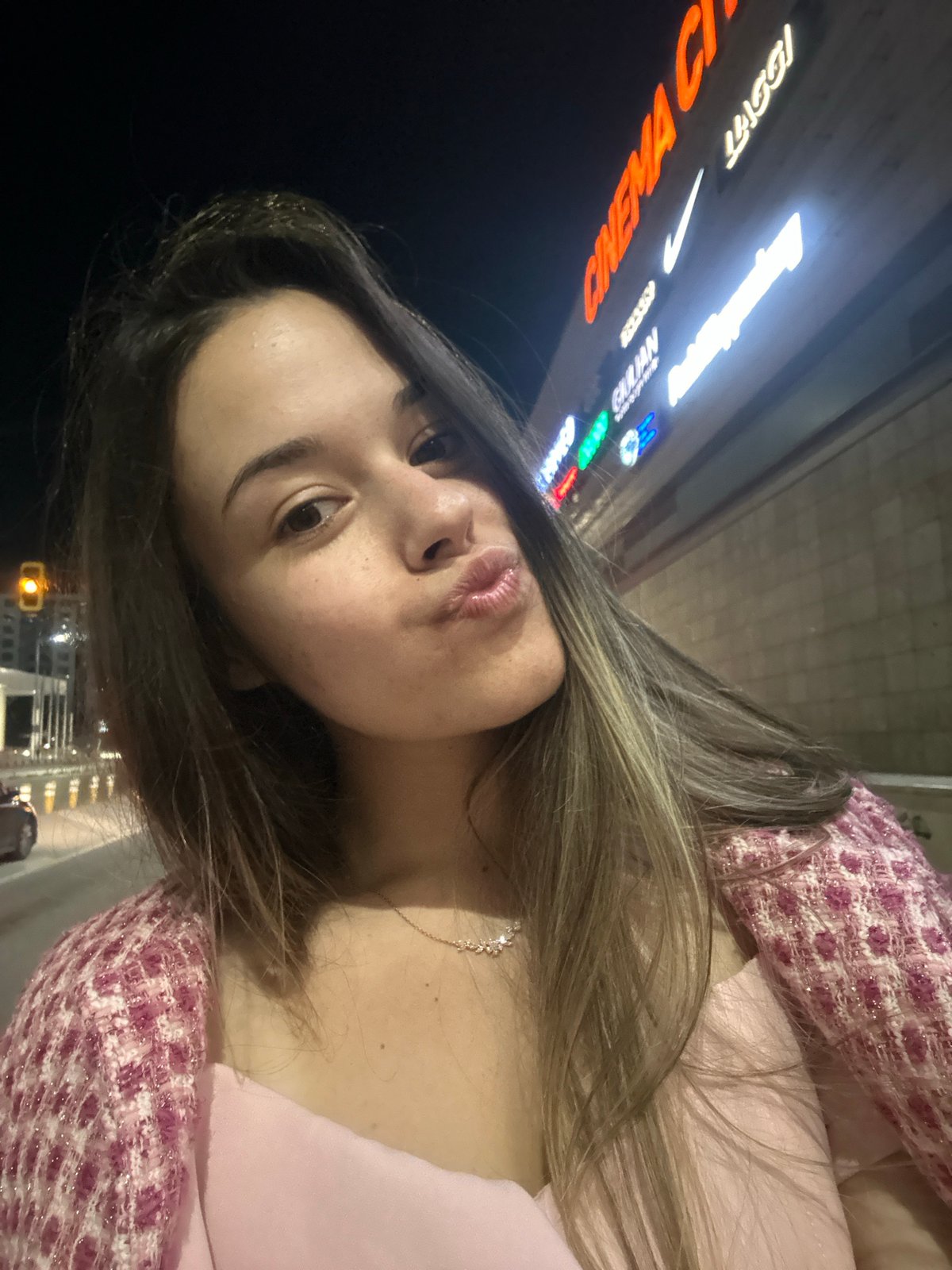 Woman takes nighttime selfies on Sofia streets near Paradise Center