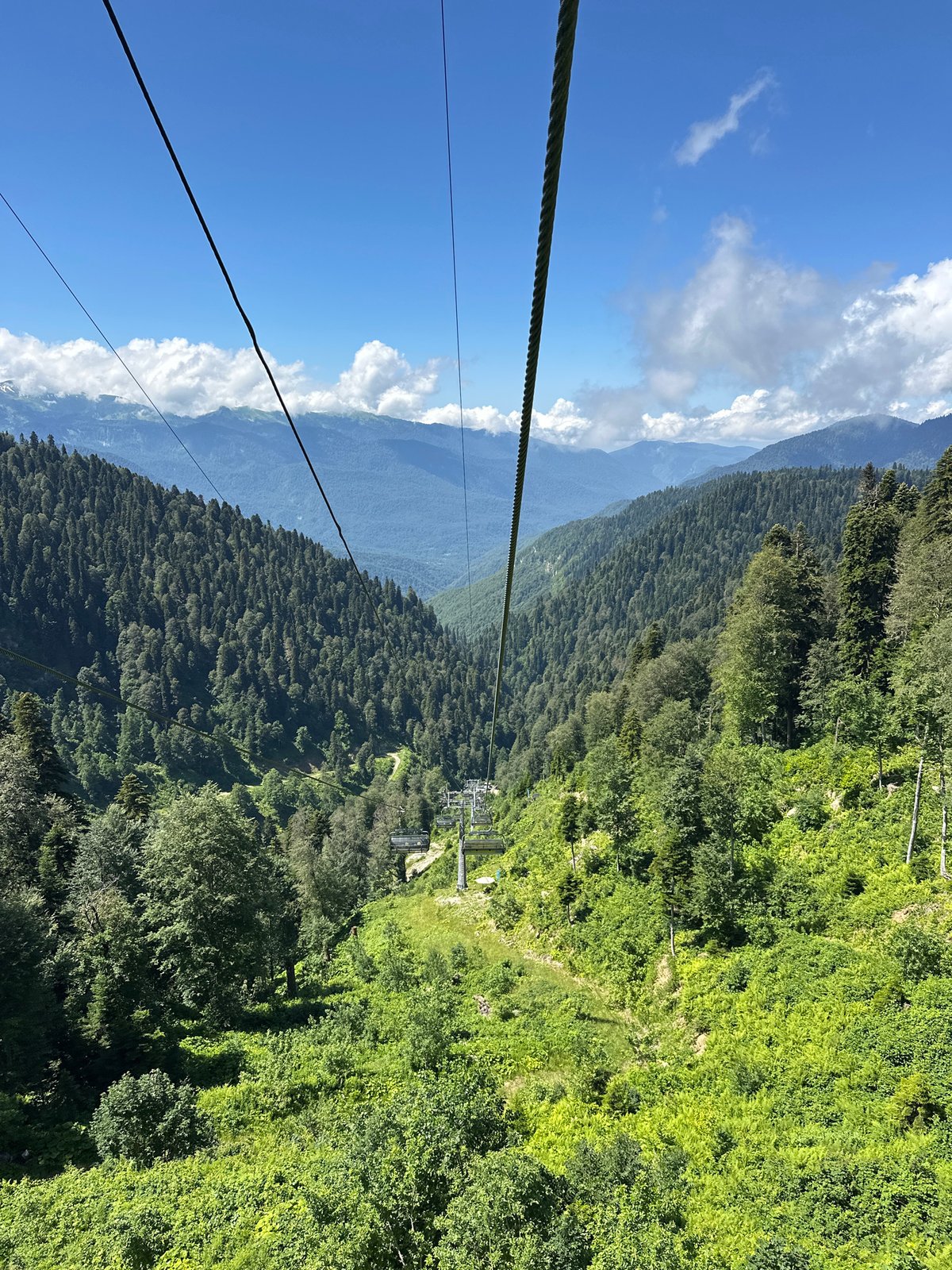 Cable car ascending forested mountain slopes in Estosadok, Russia