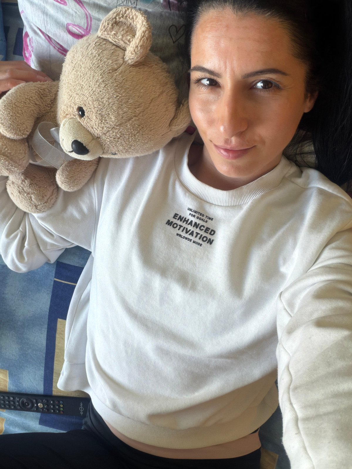 Woman rests with teddy bear on bed in Pleven