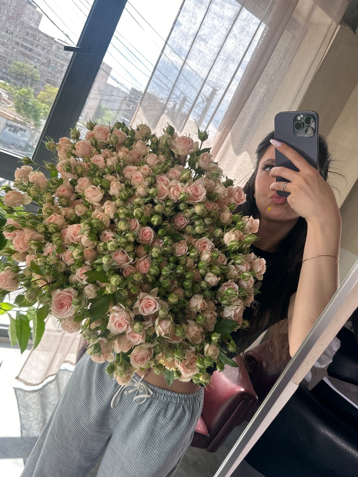 Person takes mirror selfie with pink rose bouquet in Armenia