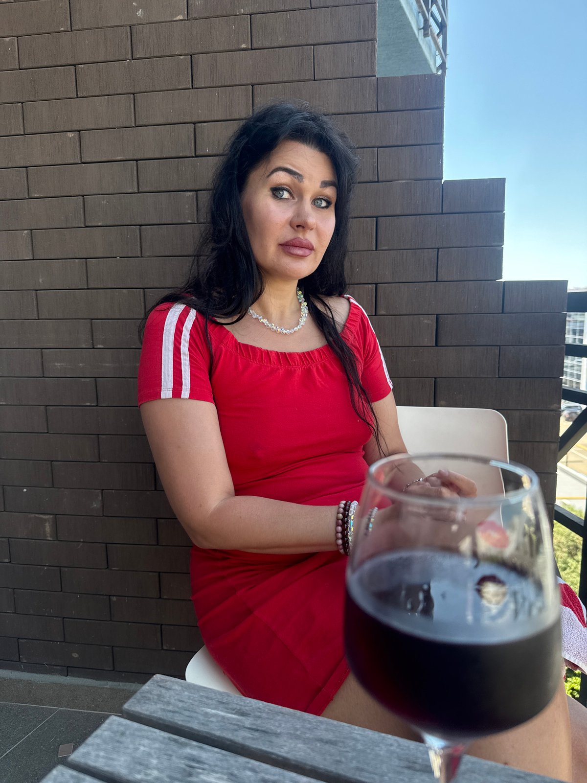 Woman enjoys morning balcony breakfast with wine in Sochi
