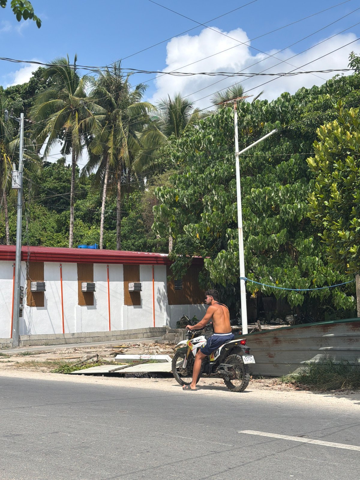 Man performs motorcycle wheelie on General Luna street