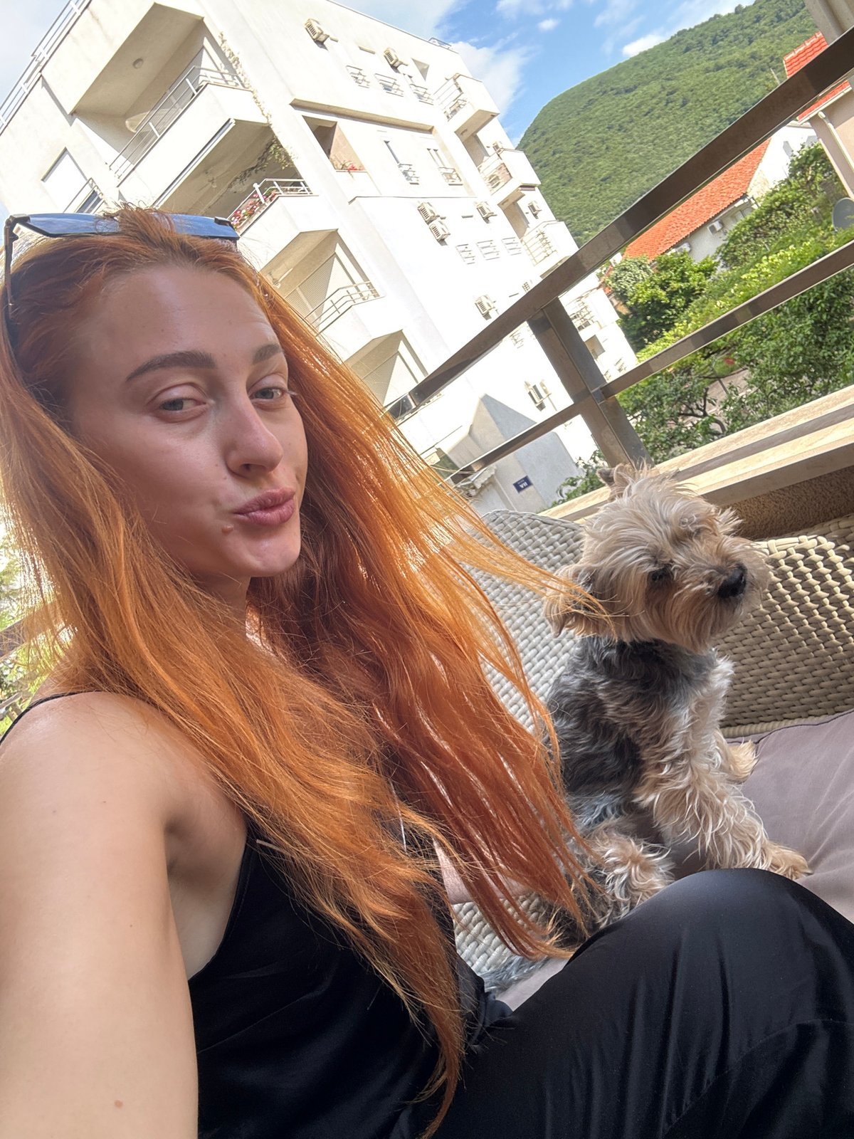 Woman and Yorkshire Terrier enjoy morning on Budva balcony